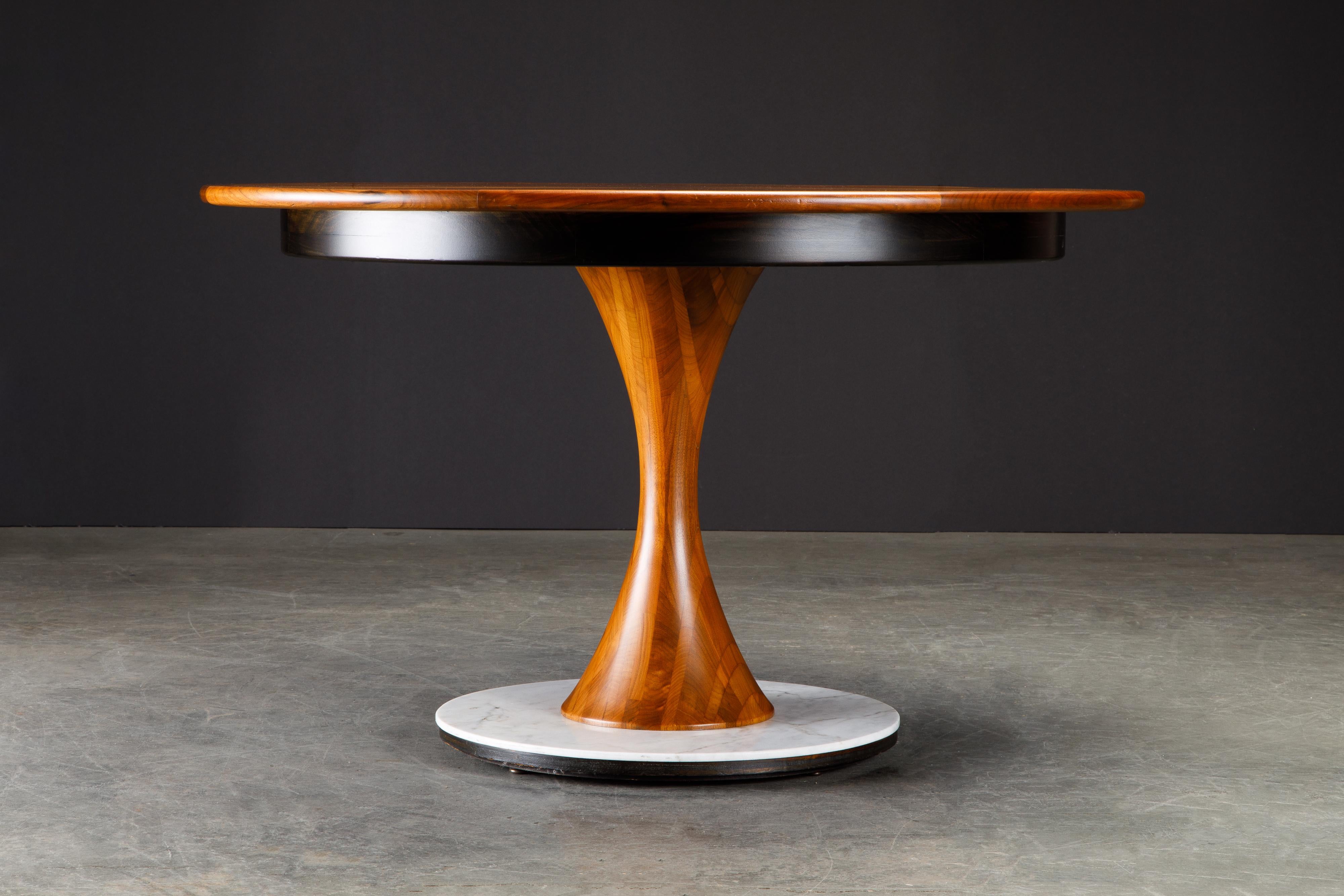 This gorgeous table, from the estate of Shari Lewis, is an exquisitely crafted custom craftsman pedestal dining table by Phillip Lloyd Powell, 1970s, sculpted from walnut, marble and ebonized wood. Signed underneath on two sections of the table: