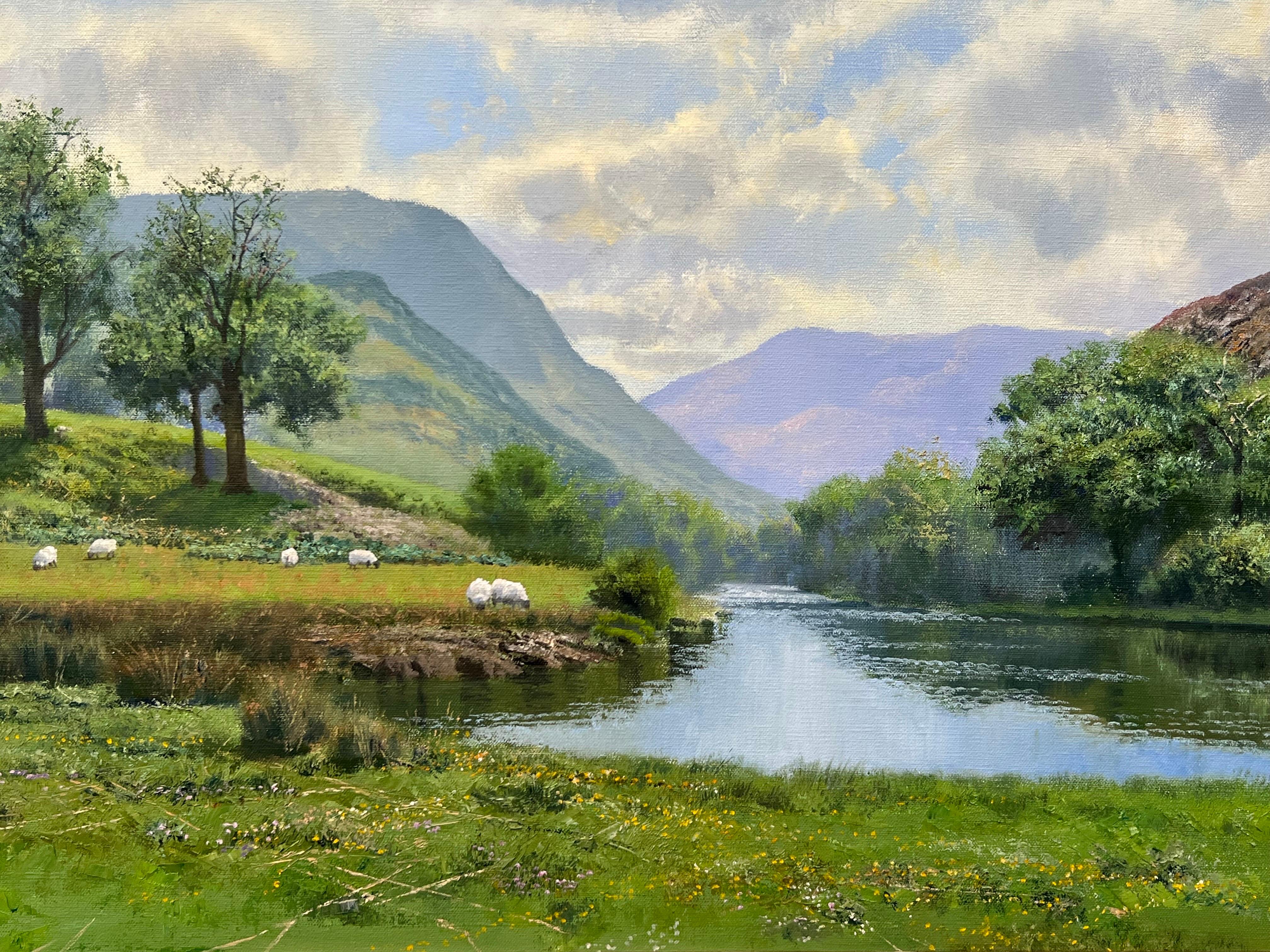 Exuberante Pintura de Paisaje de Río Verde de la Campiña Inglesa con Ovejas en los Campos y Montañas al Fondo, por el Artista Británico, Philip Stanton. ¡Se trata de un original de alta calidad, óleo sobre lienzo, en gran estado y listo para