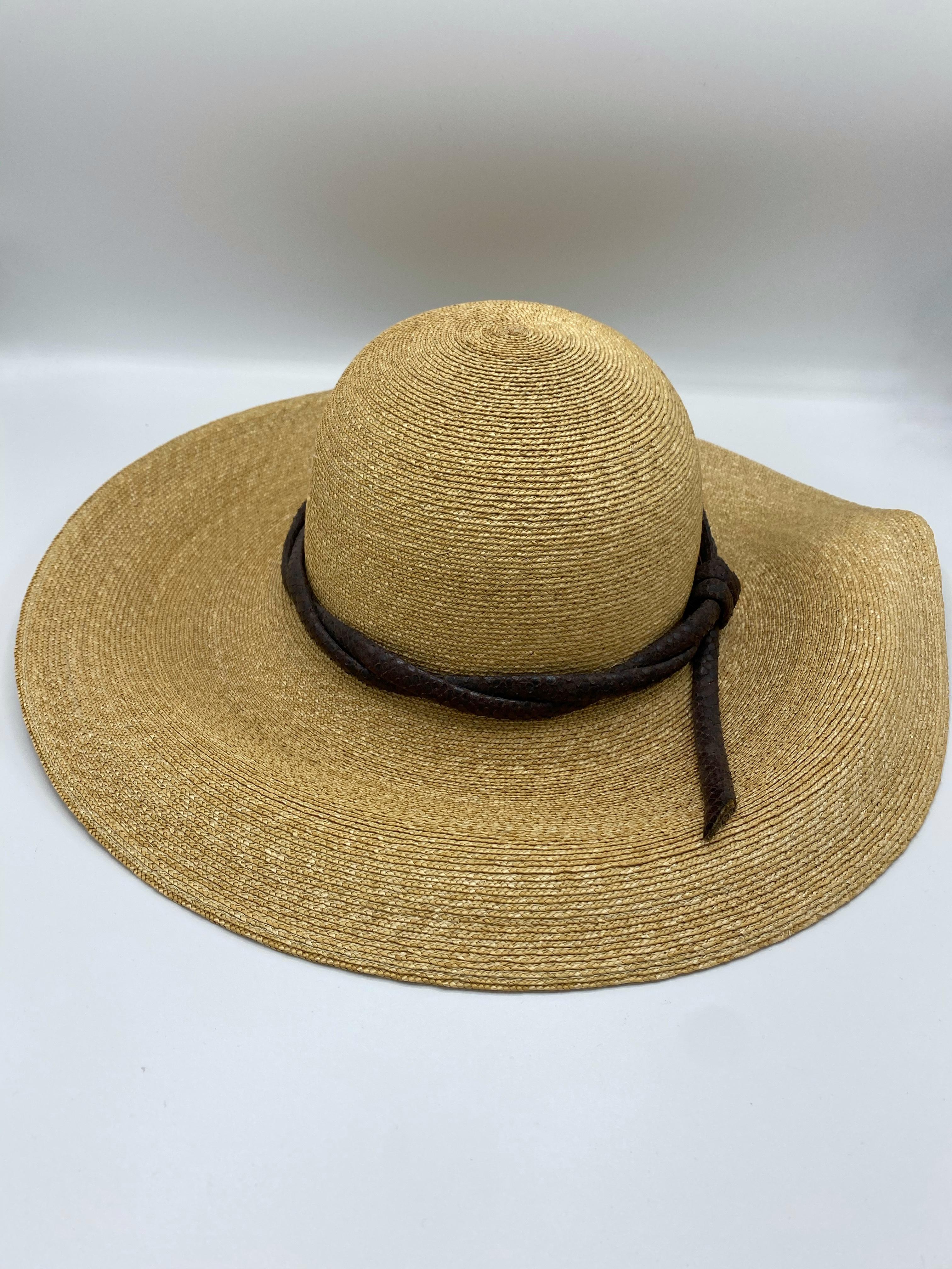 Product details:

100% natural fibers.
Featuring light beige color straw hat with brown animal skin leather cord like design detail around.
Measurements: 22