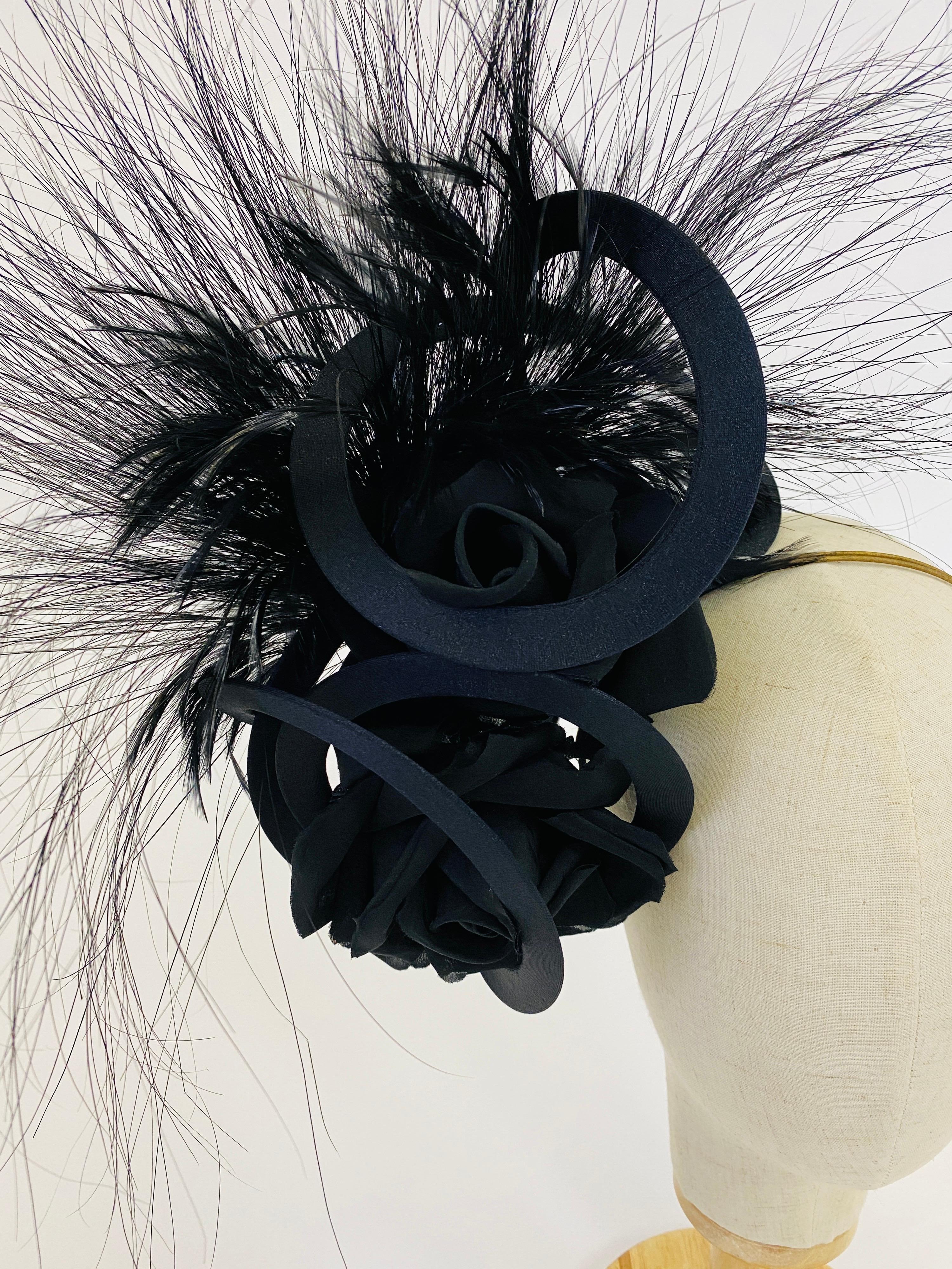 Master hat designer Philip Treacy has designed a sculptural navy fascinator with black feathers. Stunning scale and the ultimate drama abound in this design. The headpiece is attached to a wire headband that disappears into your up-do leaving only