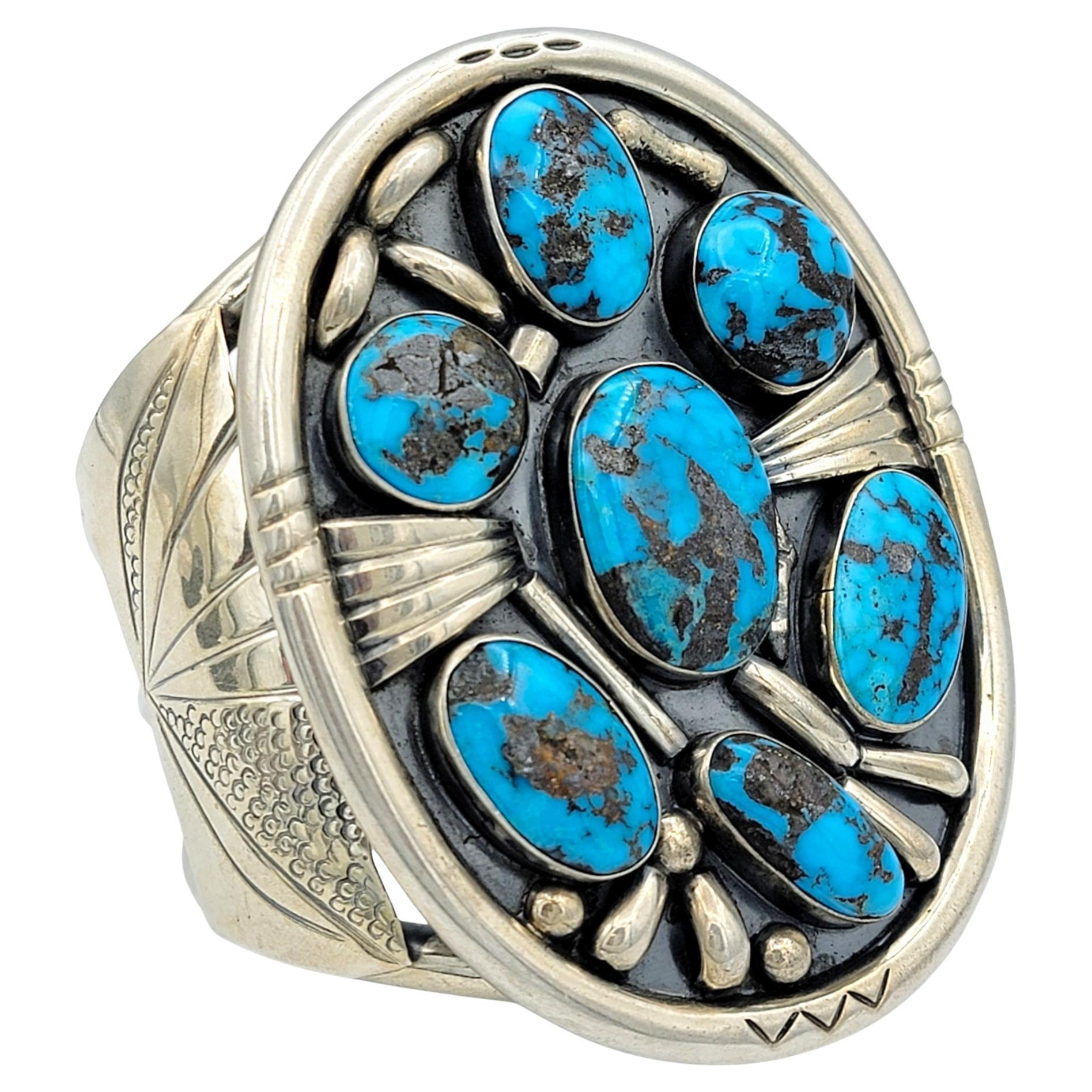 Abbraccia l'affascinante spirito del Sud-Ovest con questo squisito bracciale Navajo, realizzato a mano dal famoso argentiere Philip Tso. Questo bracciale ampio e sostanzioso, un omaggio alla tradizionale arte Navajo, è ornato da sette affascinanti