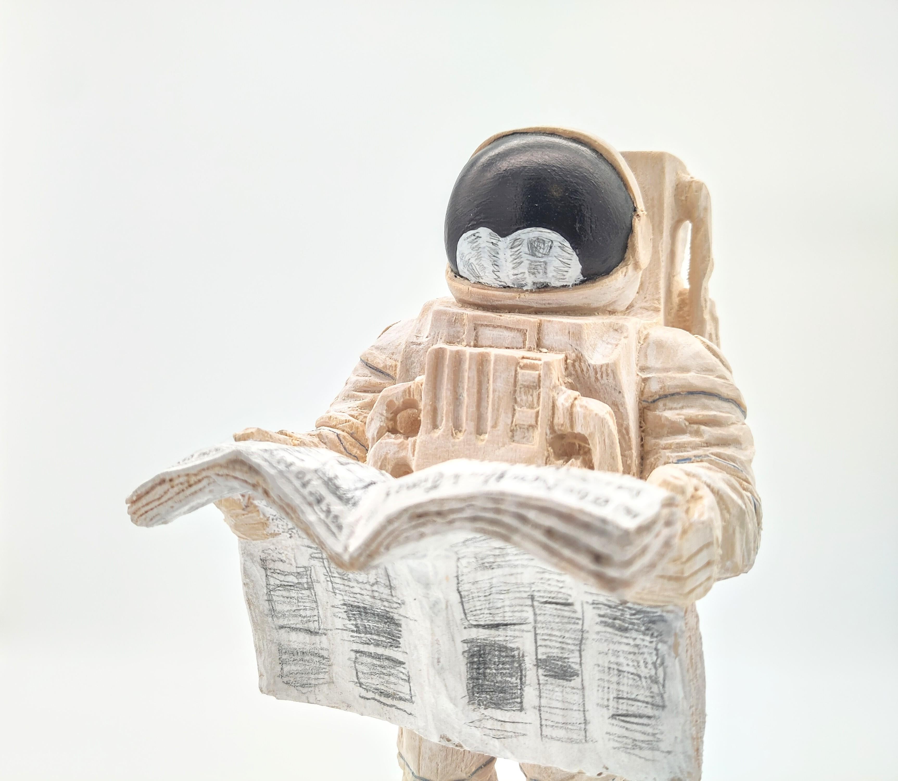 ''Noticias de la Tierra'' Escultura única de madera de astronauta con periódico - Figurative Sculpture Marrón de Philipp Liehr