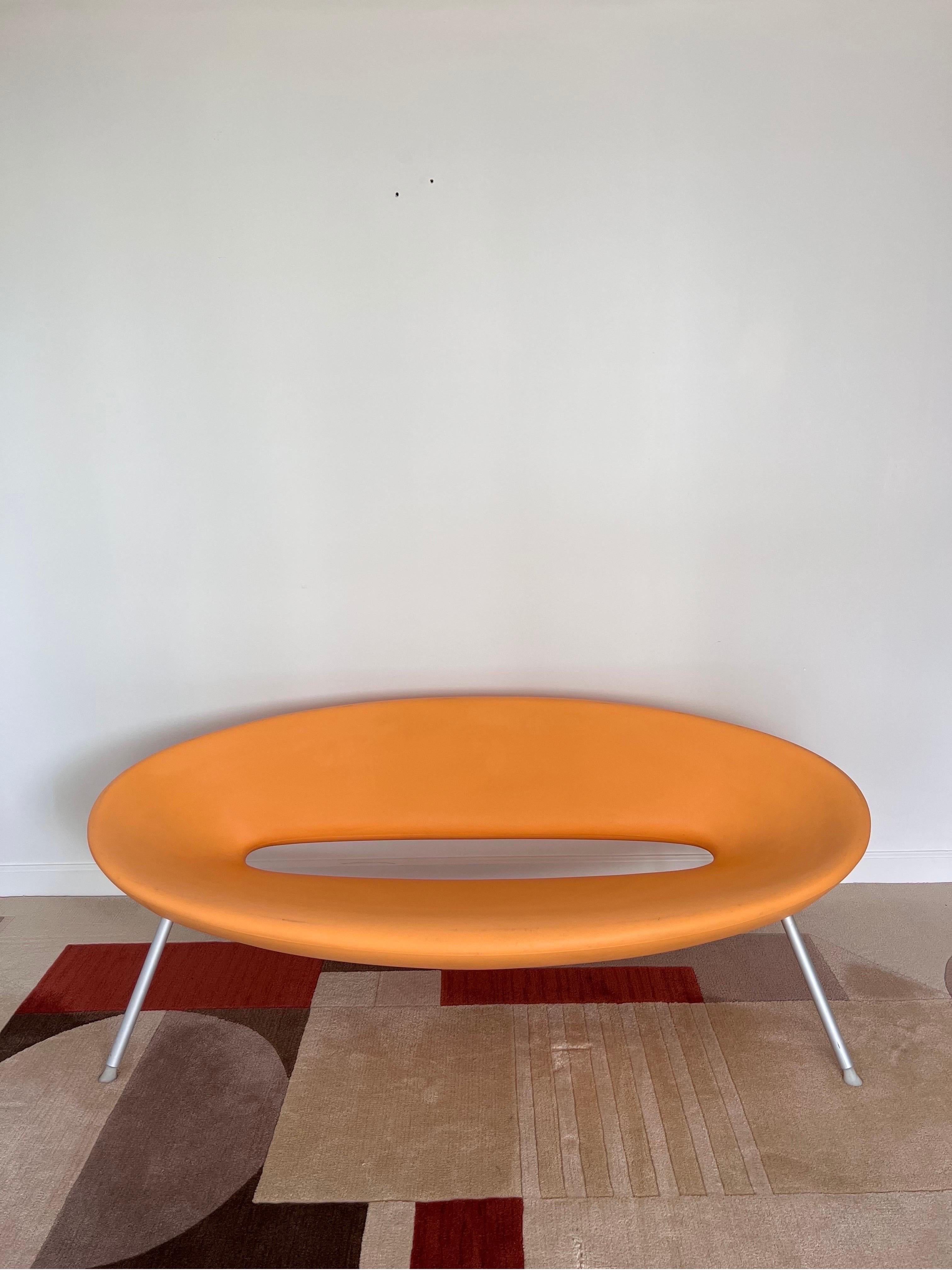 Outdoor Ploof sofa or settee in orange molded plastic with silver aluminum legs designed by Philippe Starck and manufactured by Kartell.
