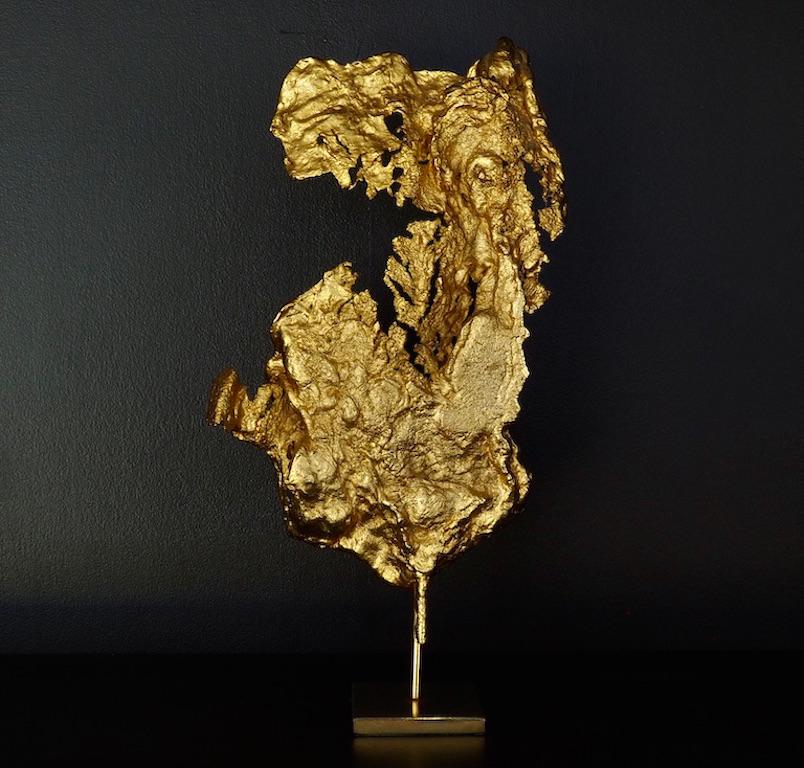 A beautiful abstract gilded metal sculpture by Philippe Cheverny in the form of a gold nugget on a brass stand. 
These were made by pouring molten metal into free form shapes before gilding, as a result each one is unique.
Small gilded sculptures