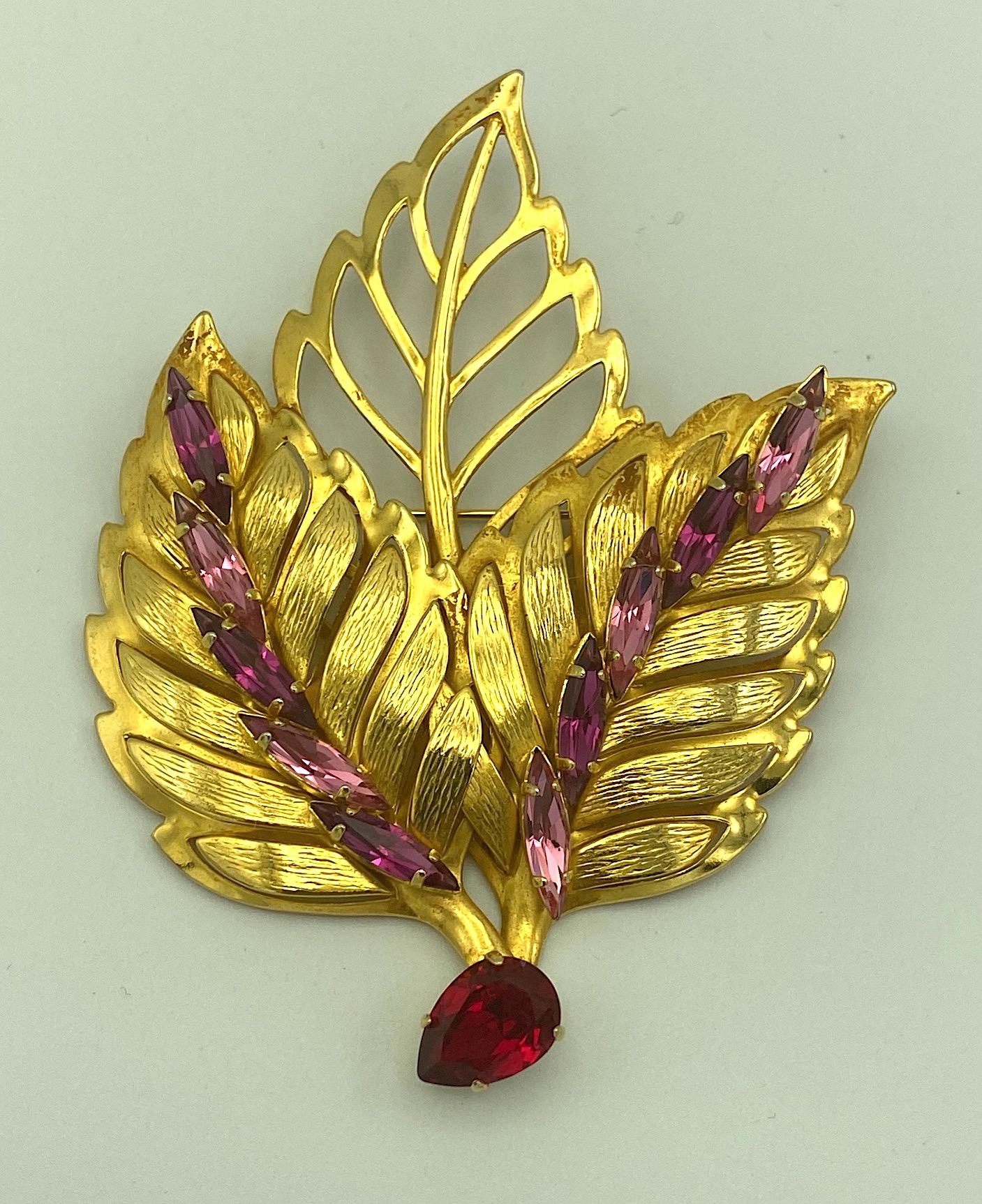 A beautiful triple leaf brooch from the 1980s by French fashion jewelry designer Philippe Ferrandis. The pieces is comprised of large leaves in textured and smooth 18K gold plate. The back leaf has cut out veining leaving open spaces. The front two