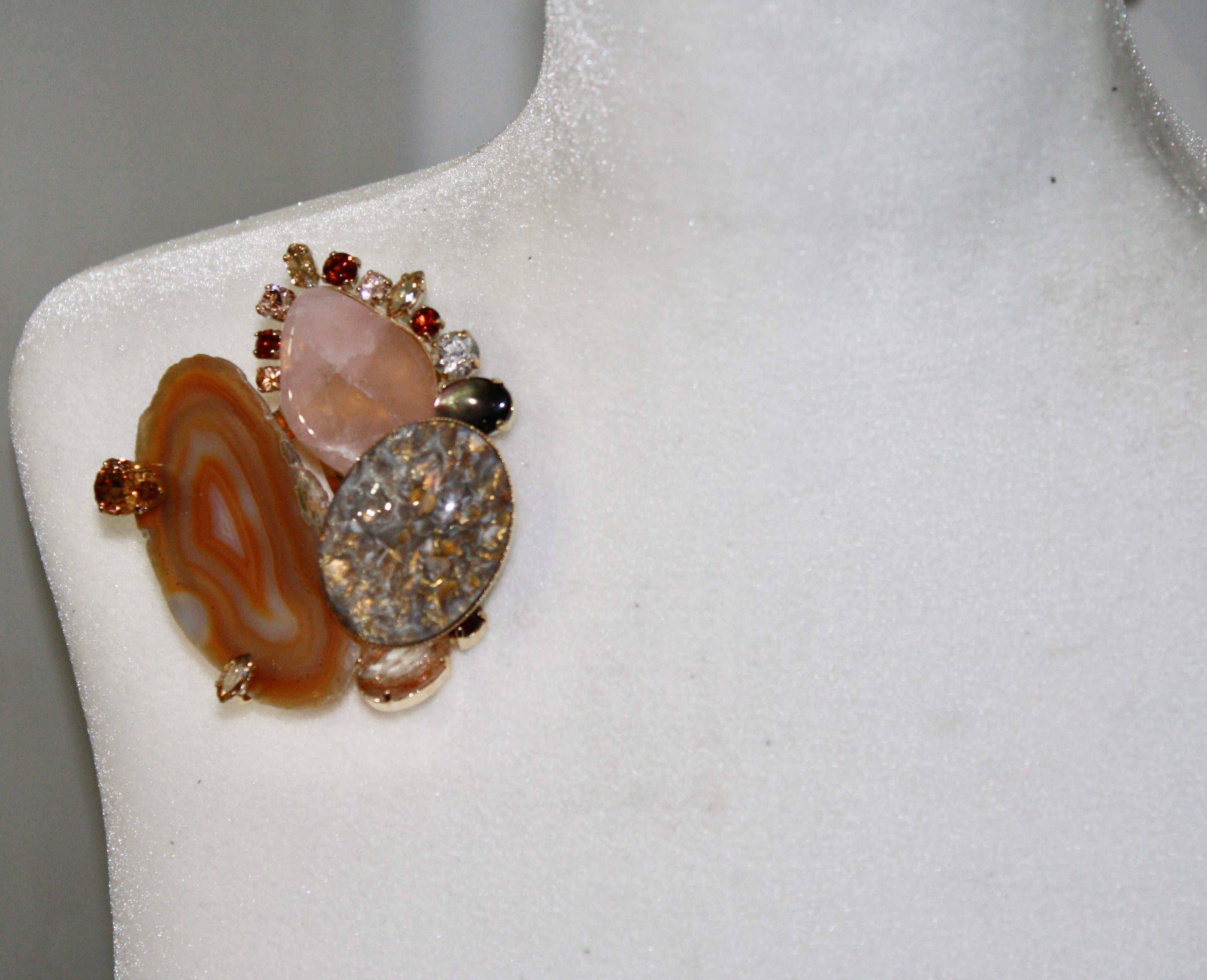 Agate, pink quartz, handmade glass cabochons and Swarovski crystal set on brass plated gold. A hook in the back allows the pin to be worn as a pendant.