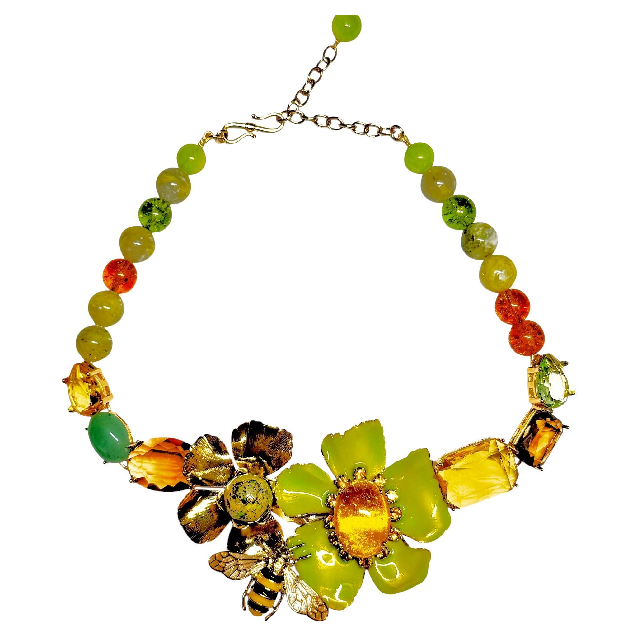 This necklace unfolds a bouquet of lacquered flowers and golden stones like a Bagatelle flowerbed

Finely enameled metal flowers on a 24-karat gold-plated brass structure. Green fluorite and aventurine, faceted brown and honey crystals. Natural