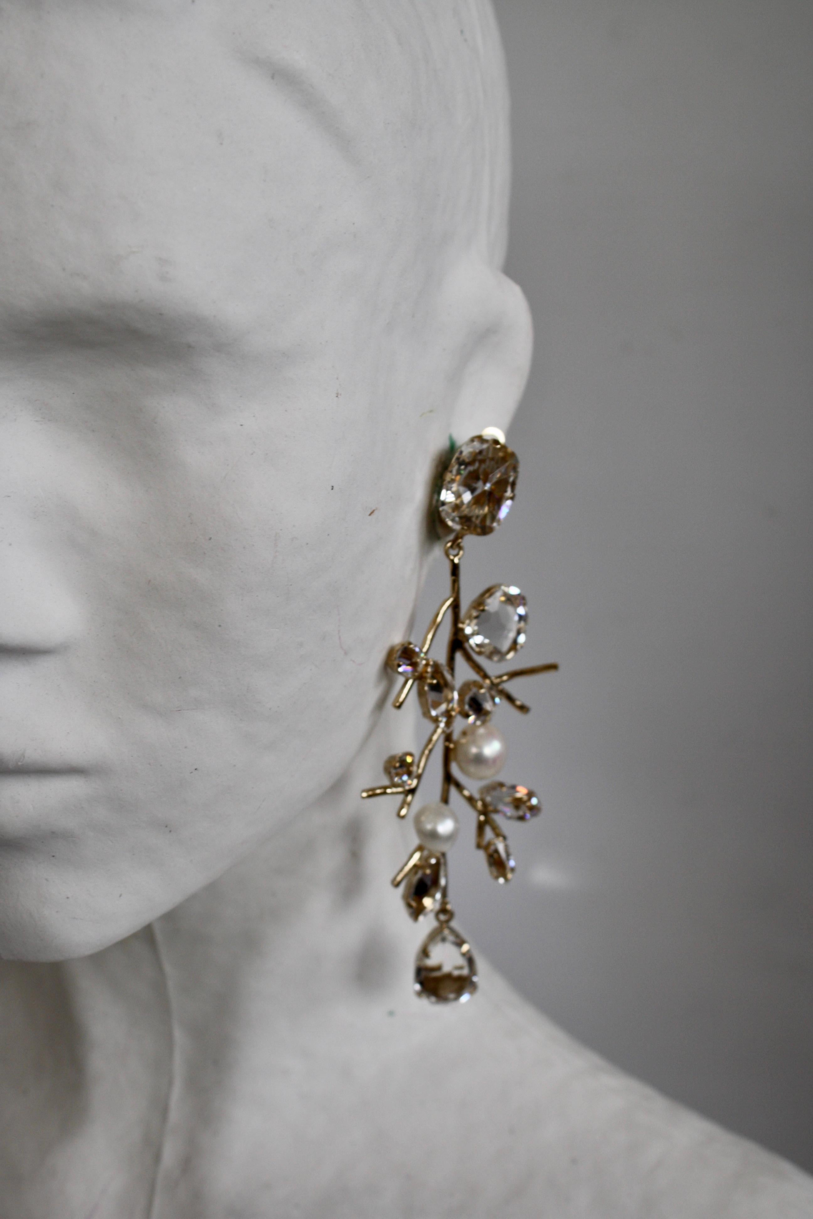 Pale gold metallic treatment, Crystal, and Swarovski pearl clip earrings from Philippe Ferrandis. 