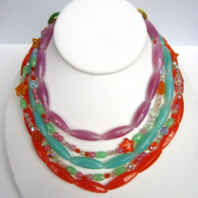 5 Strand Multicolored Bib necklace. Great pastel colors make up the layering on this one. Extra chain gives you some adjustment with the length. Orange, Purple and a Blueish Green make up the larger beads... Stars detail the smaller strands. Large