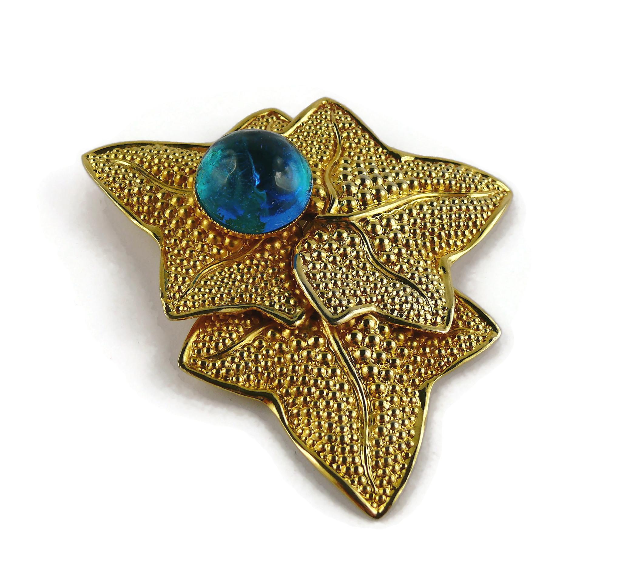 PHILIPPE FERRANDIS vintage massive gold toned brooch featuring 3 textured leaves embellished with an acqua blue irregular shaped resin cabochon.

Marked PHILIPPE FERRANDIS PARIS.

Indicative measurements : max. height approx. 8.3 cm (3.27 inches) /