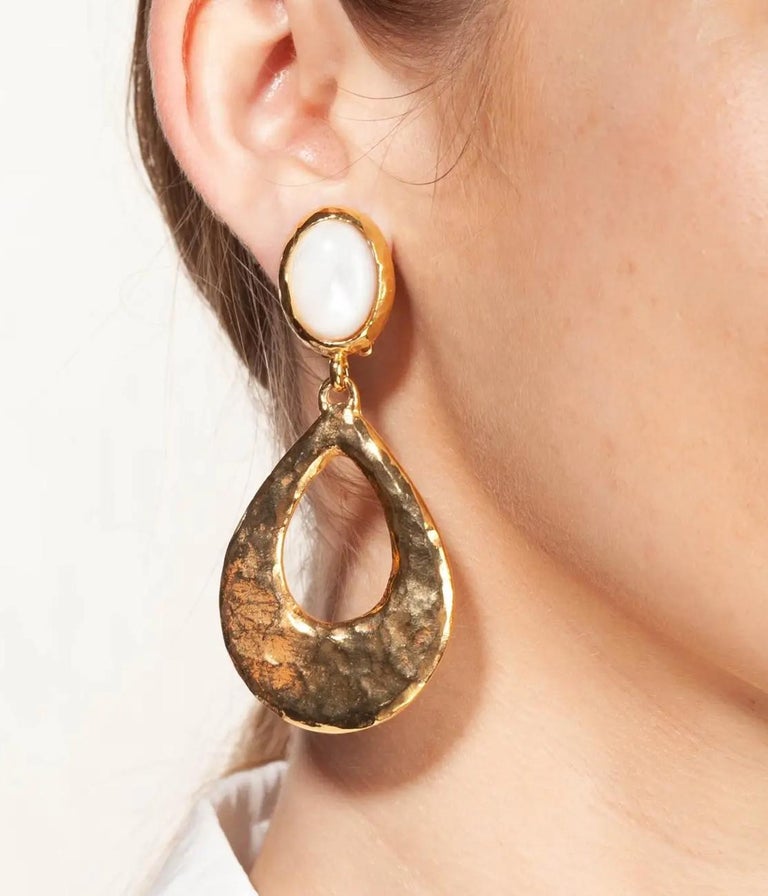 A pair of earrings made of hammered golden metal and natural stone cabochons.
This pair of earrings with a vintage, colourful and shimmering look will affirm your style.
Made in France
Philippe Ferrandis, French luxury designer. 
His jewels are