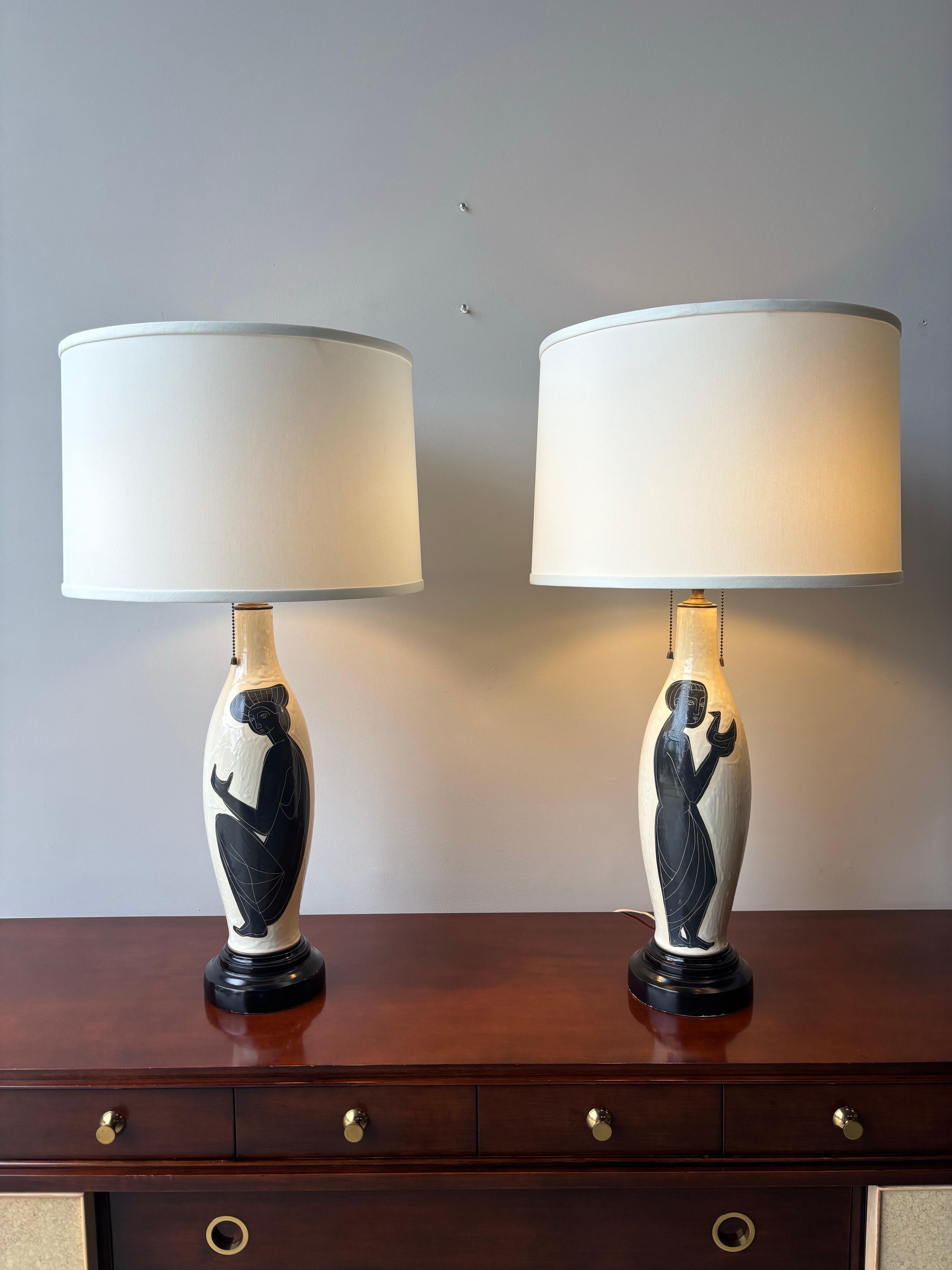 Cette paire de lampes de table en céramique de l'artiste suisse renommé Philippe Lambercy illustre l'élégance moderne du milieu du siècle avec une inspiration classique. Chaque lampe présente un corps gracieux en céramique en forme de bouteille, de