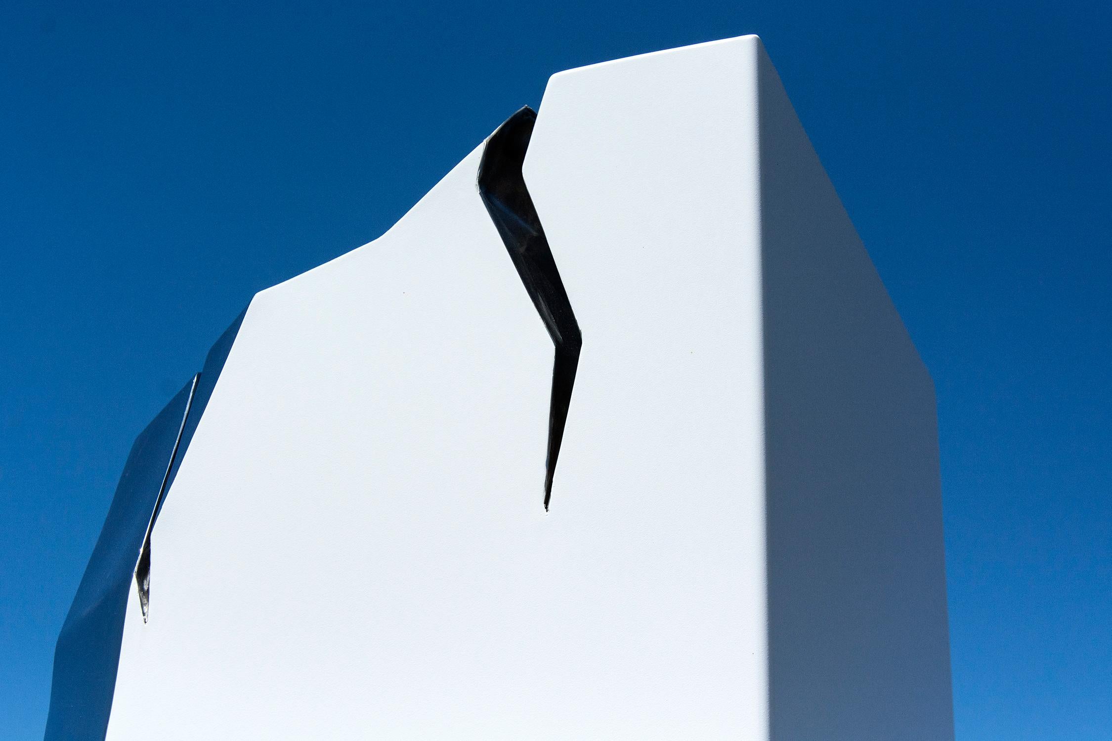 Bei dieser minimalistischen Außenskulptur von Philippe Pallafray ist eine Säule aus Edelstahl weiß beschichtet. Die Skulptur ist mit gezackten, polierten Rissen im Stahl versehen, die im Sonnenlicht glitzern. Der Künstler schrieb dem reflektierten