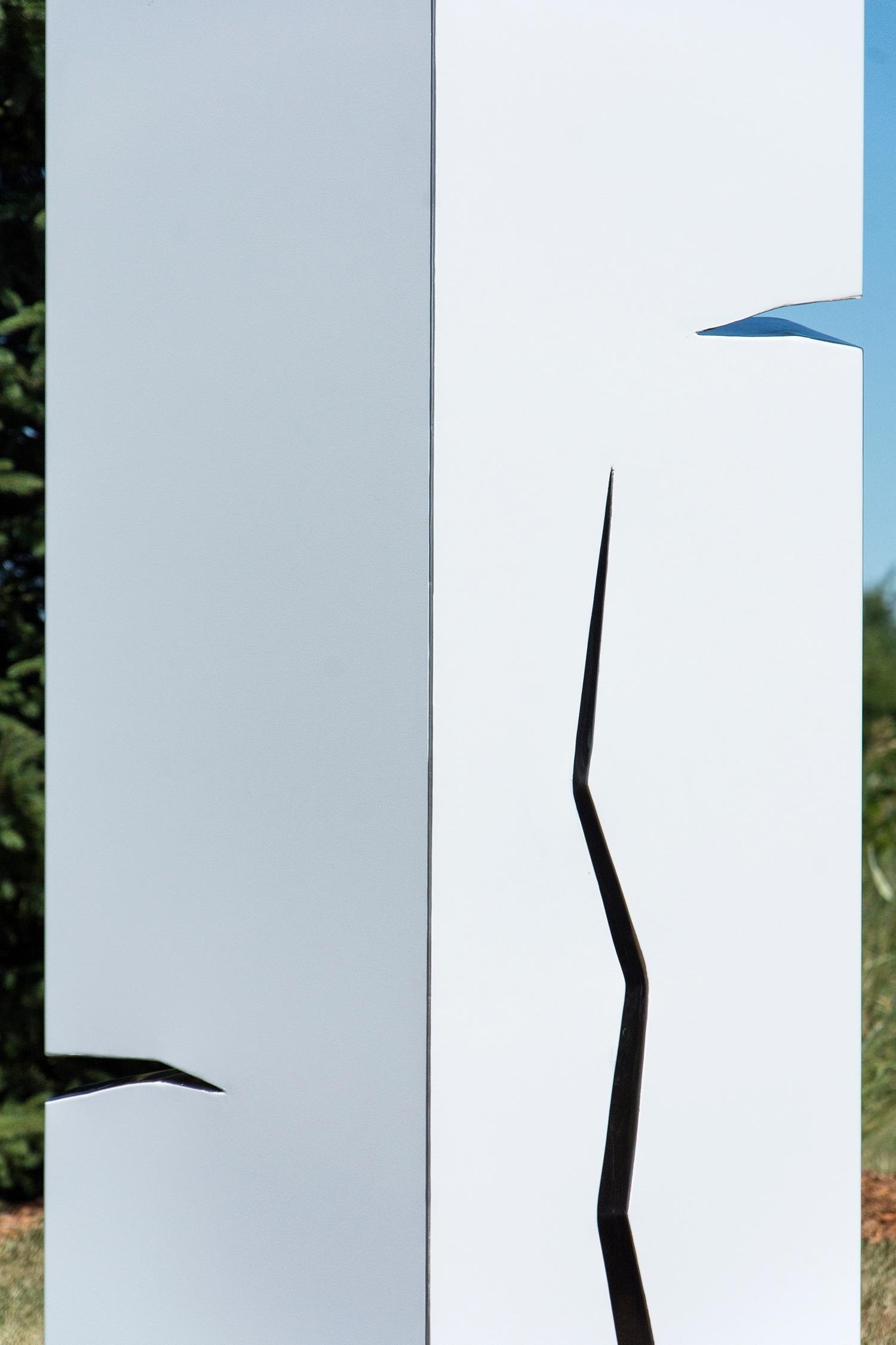A pillar of stainless steel is coated white in this minimalist outdoor sculpture by Philippe Pallafray. The sculpture is designed with jagged polished cracks in the steel that glint in the sunlight. The artist ascribed meaning to reflected light by