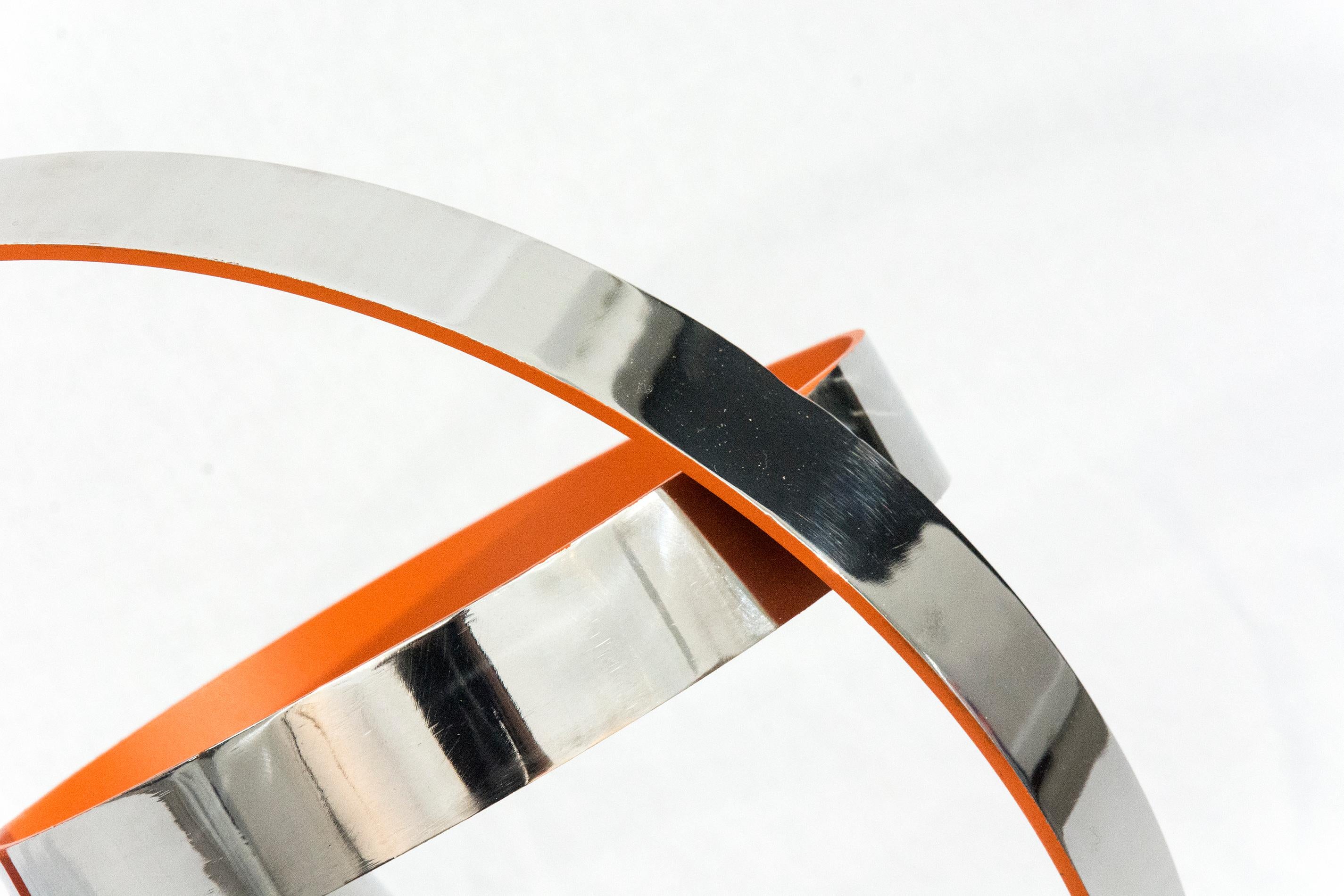 In his geometric sculptures, Philippe Pallafray intersects rings of polished stainless steel, the edges patinated in hot  orange crush. His minimalist approach is paced, cool and echoed in the series title, Temps Zero or “timeless”.  This work is