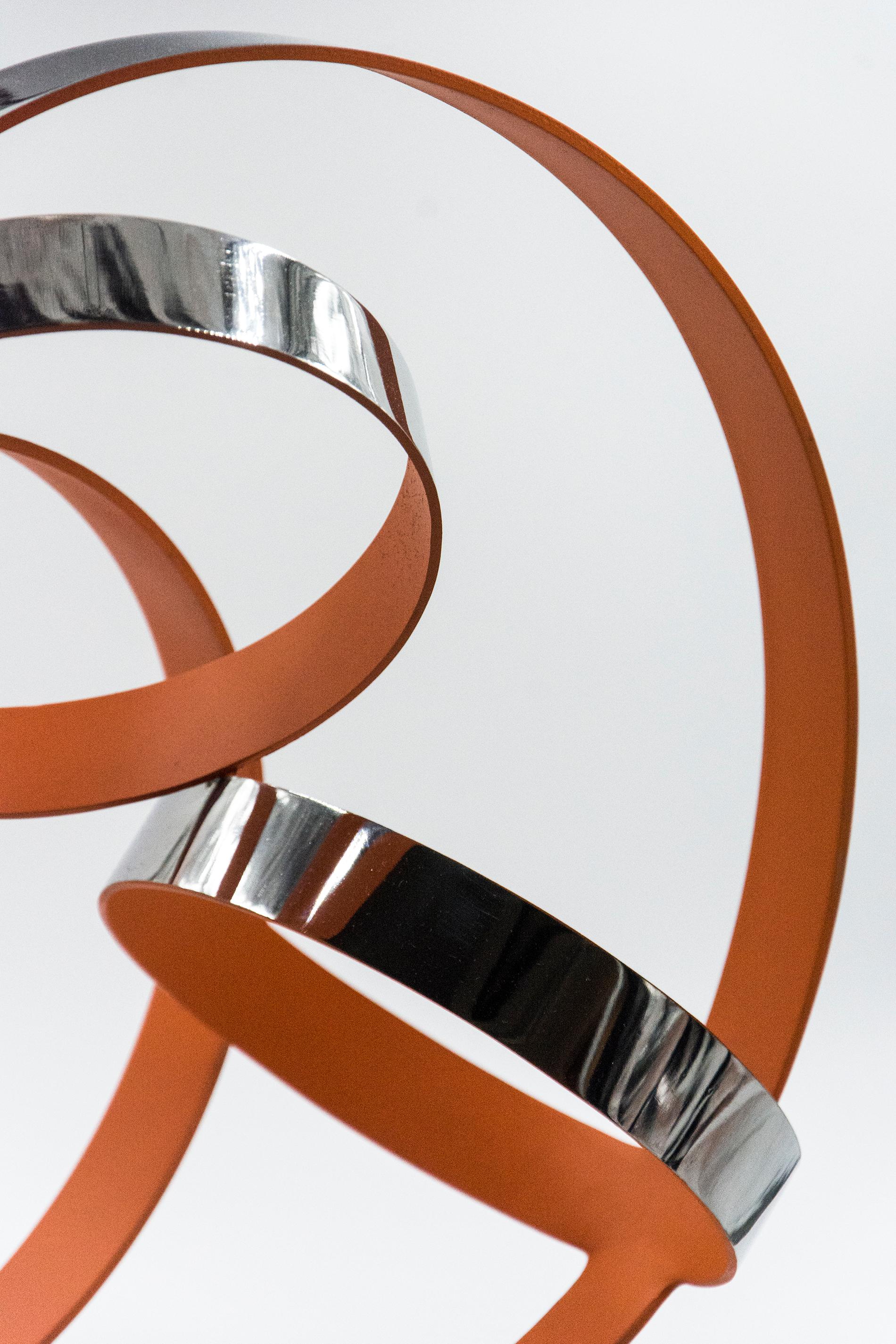 The bright orange interior of these stainless-steel rings by Phillipe Pallafray provides a stunning contrast to the highly polished reflective exterior of this abstract sculpture. Pallafray’s work is designed to represent the duality of nature and