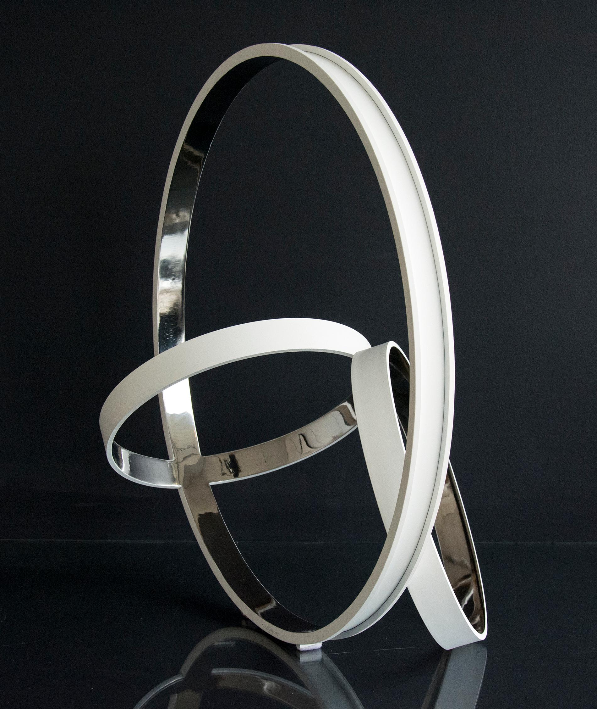 Trois anneaux d'acier inoxydable, polis et brillants à l'intérieur et blancs mats à l'extérieur, se croisent à des angles dynamiques dans cette élégante sculpture de Philippe Pallafray.

Philippe Pallafray (né en 1965, France) est membre de la