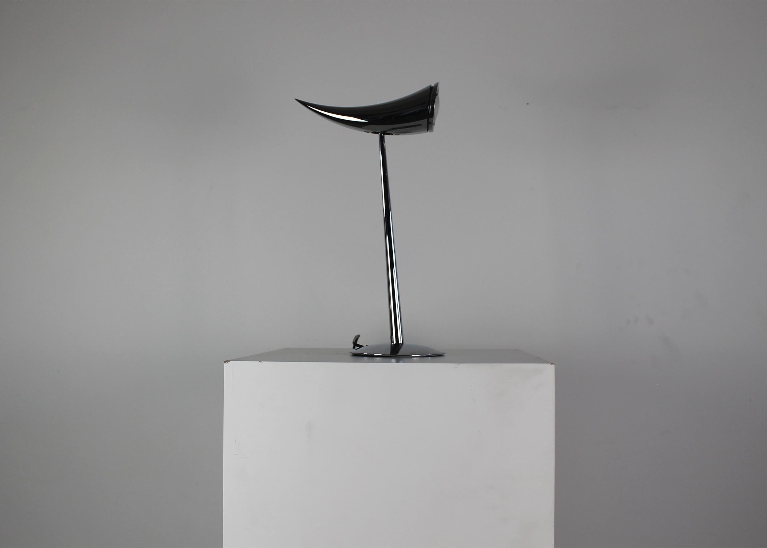 Ara table or desk lamp in polished chrome provides direct illumination. The head adjusts to direct lighting at a 90-degree angle.
Designed by Philippe Starck in 1988 for Flos.

Measurements:
Height: 55 – 56.5 cm
Lampshade: 27.5 cm
Base: Ø 17.5