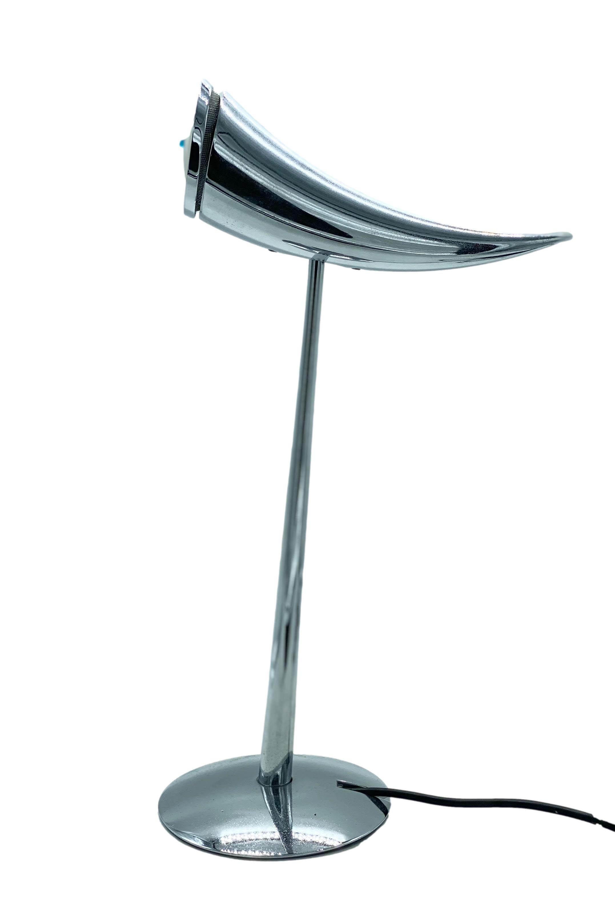 Elegant Ara table lamp designed by Philippe Starck and produced by Flos Italia in 1988. The lamp is in very good working condition. If you tilt the top of the lamp upwards, the light goes out. If you tilt it downwards, the light comes on.