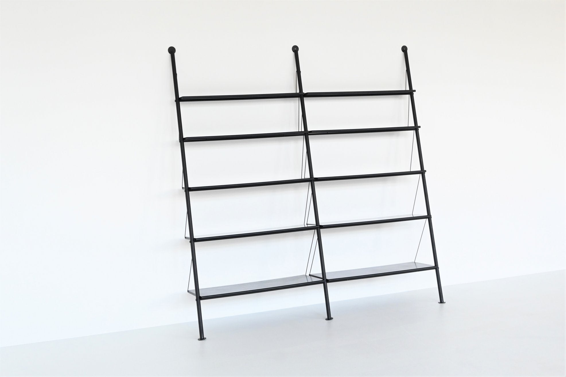 Beauiful and hard to find double shelving unit or bookcase model John Ild designed by Philippe Starck for Disform in Italy 1977. This very nice wall unit consists of three black coated tubular metal rods which supports ten black lacquered wooden