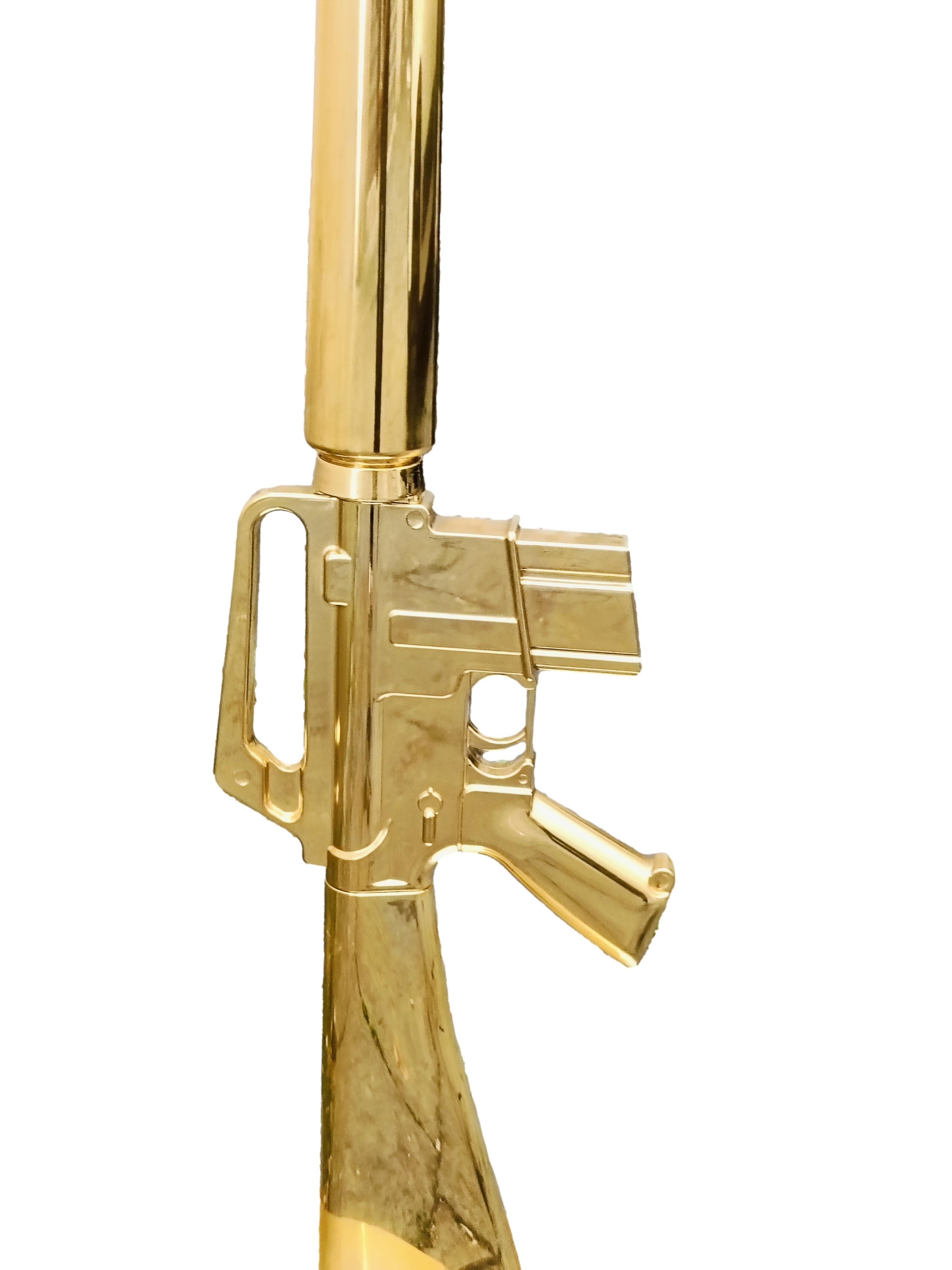  Guns Lounge M16 lampadaire conçu par Philippe Stark pour la collection Guns. Corps en aluminium avec finition électrolytique en or 18 carats poli. Diffuseur en papier plastifié noir mat avec sérigraphie dorée à l'intérieur. Gun (également connue