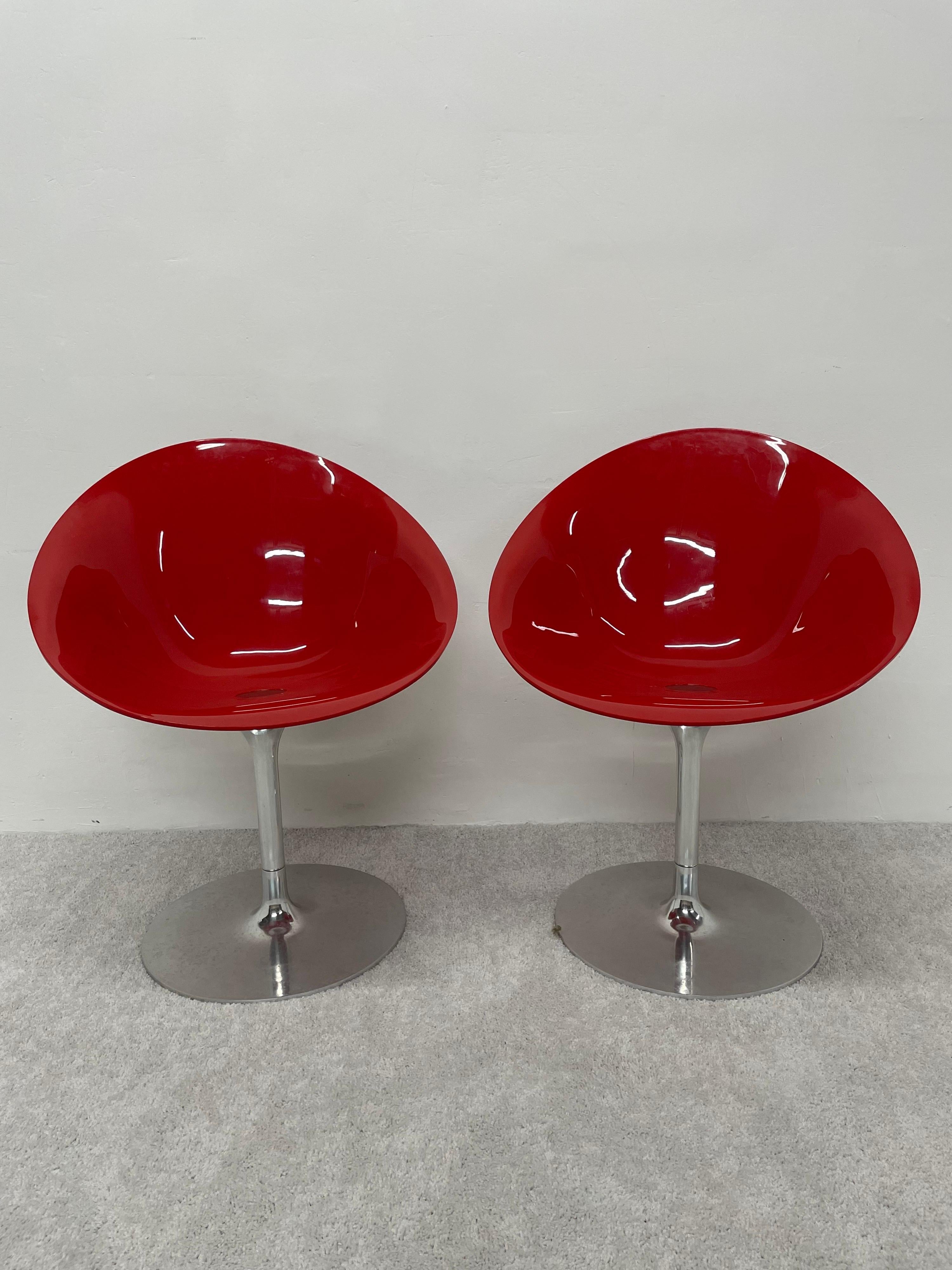 Pair of glossy red polycarbonate Eros chairs on aluminum trumpet swivel bases by Philippe Starck for Kartell. Made in Italy. The red polycarbonate seat is not transparent. 
