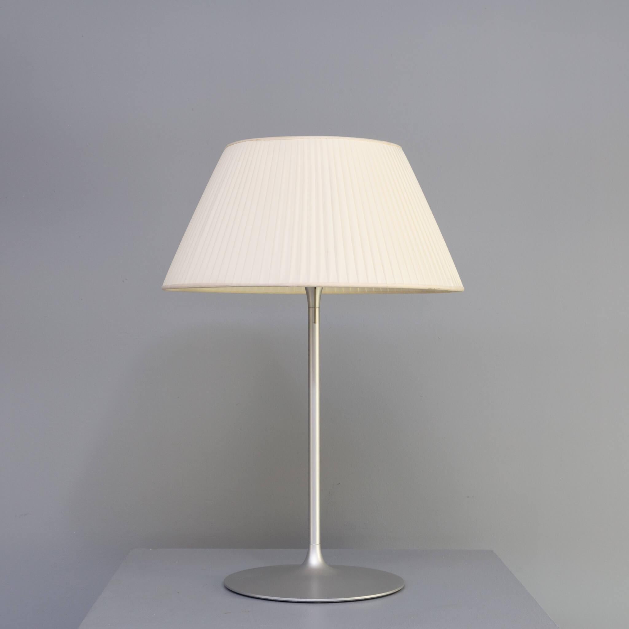 Philippe Starck designed the Romeo series of table lamps specially for Flos (meaning Flower in Italian). The lamp has been delivered in different versions in size but also in different hoods, There are lamps with glass hoods and fabric shades. This