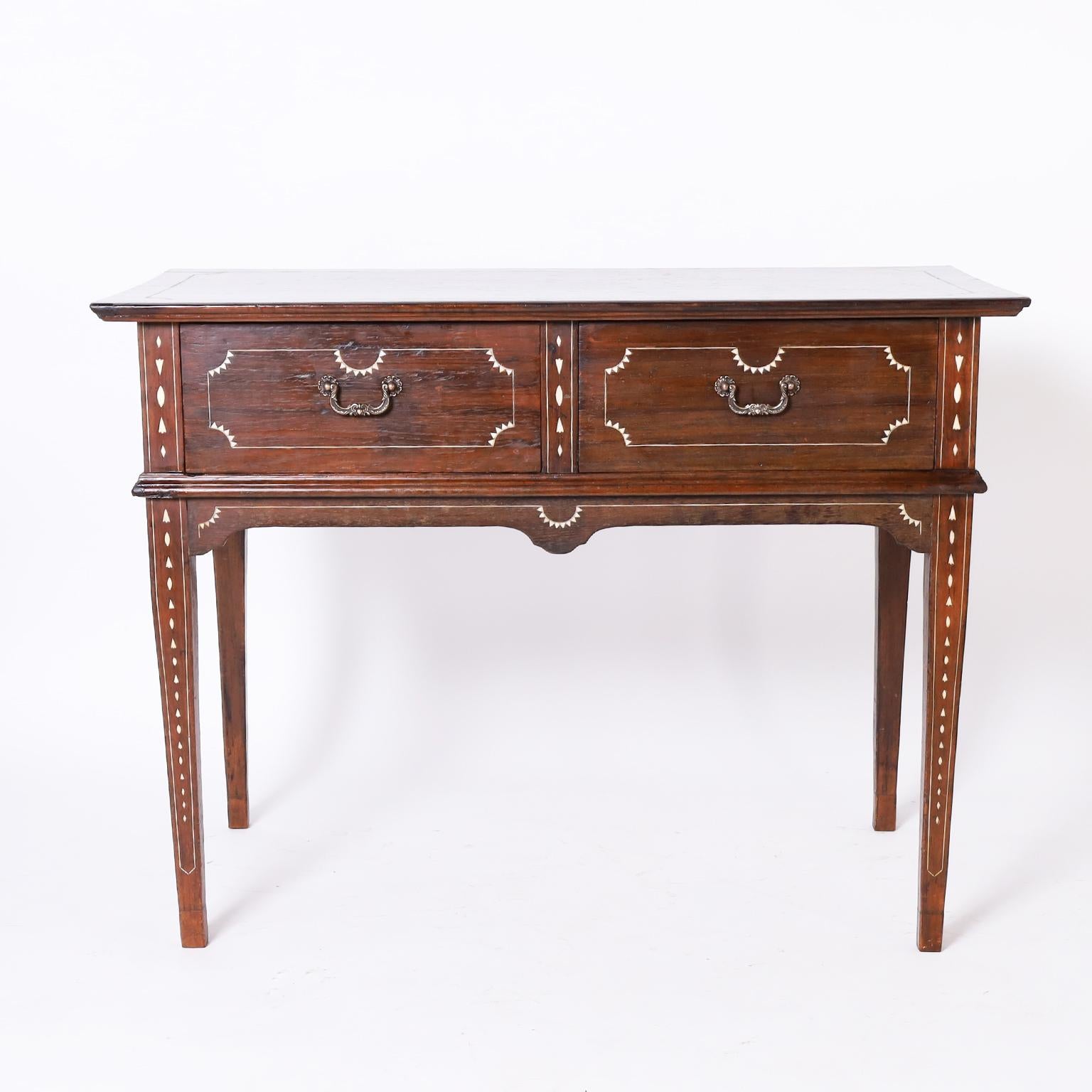 Sideboard from the Philippines, often confused with Anglo Indian,crafted in rosewood with classic practical form having two drawers with brass hardware, geometric bone inlays, and long tapered legs.  