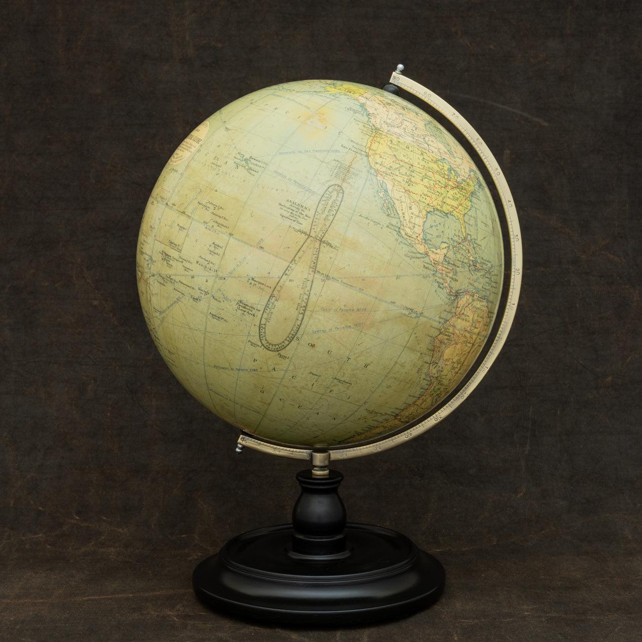 An attractive terrestrial globe by George Philip and Son; circa 1925. Printed in several colours and mounted on a brass semi-meridian attached to original turned ebonized wooden base and upright. The globe comprises of twelve coated lithographic