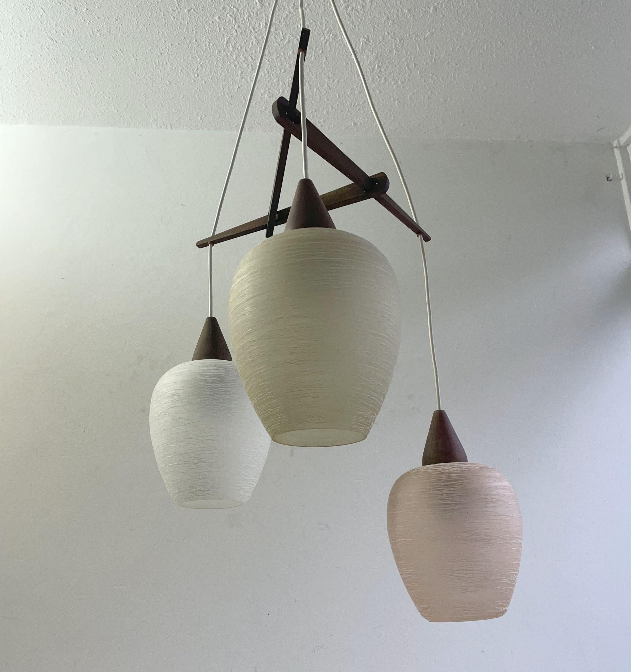 Lampada a sospensione calda proveniente dai Paesi Bassi, anni '50. 
Diametro del vetro 17 cm,  altezza 20 cm. Buone condizioni d'epoca, il bordo inferiore è eccellente, quello superiore presenta delle pulci nel punto in cui il metallo tocca il vetro.