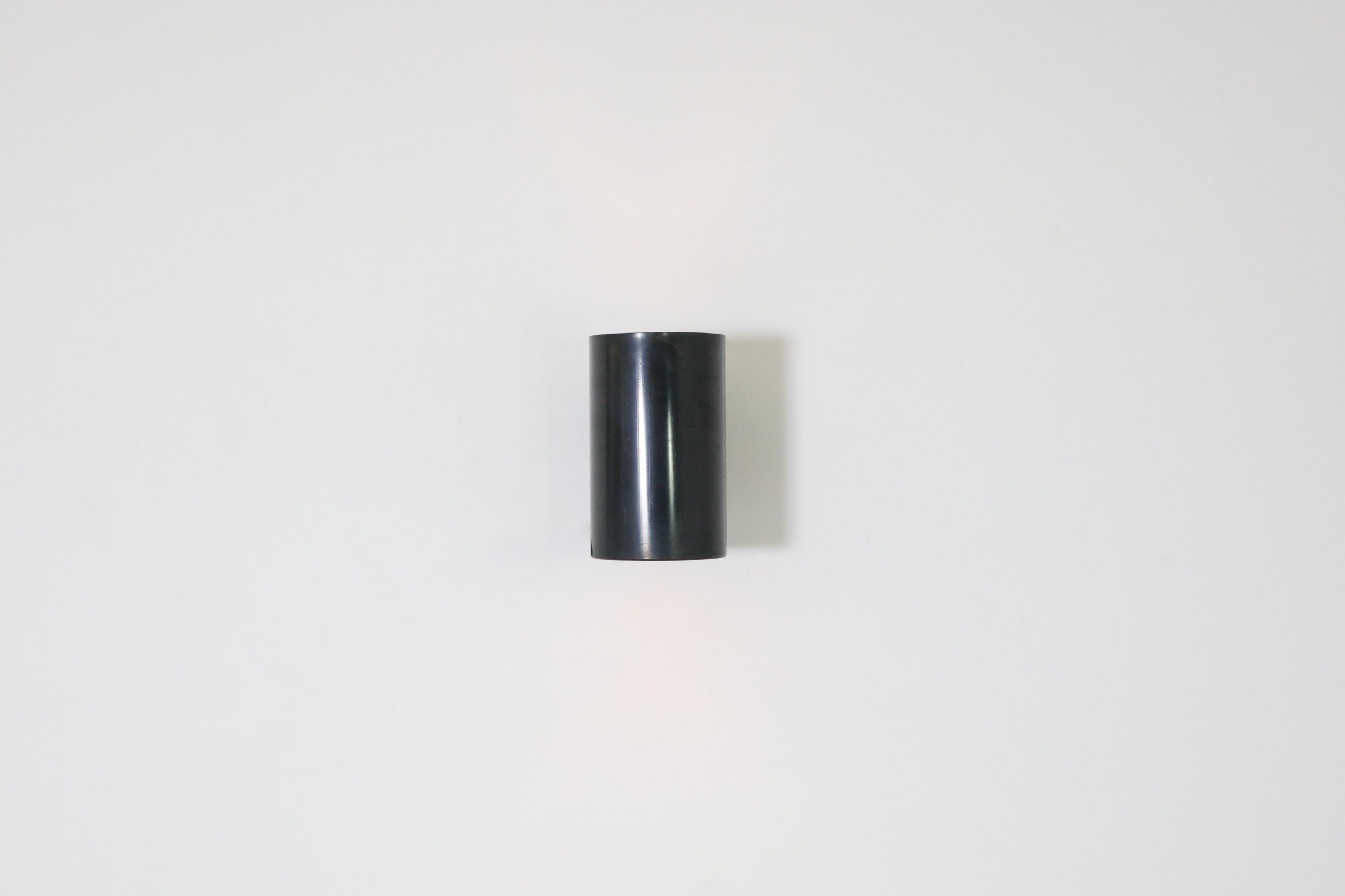 Dutch Mid-Century, Philips manufactured, black enameled metal cylinder wall sconces. In original condition with some visible wear including scratching and possible denting. Wear may vary from lamp to lamp and is consistent with age and use. Sold