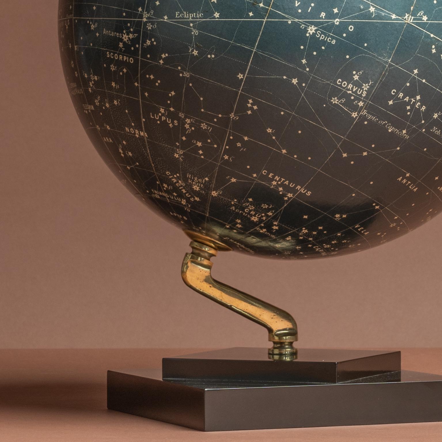 A stylish celestial globe on a brass inclined plain mount attached to original square bakelite base and secured at the top by a brass acorn finial. By George Philip and Son; circa 1935. A cartouche is present that includes the title and maker's