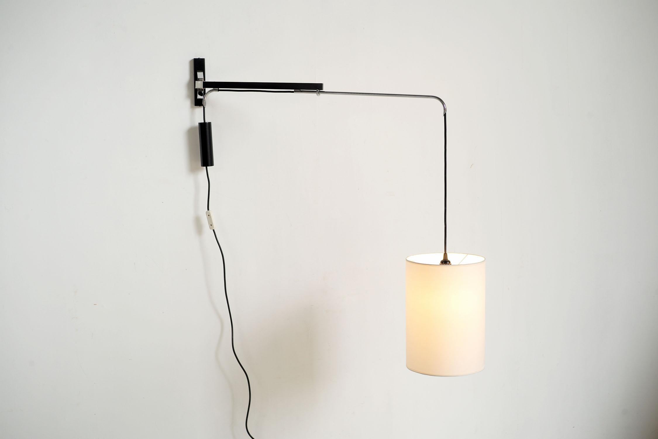 Remarkable counterweighted gallows in black lacquered metal and chrome from Philips, Holland 1960. The joint allows the light arm to pivot, which slides to reach a span of 105 cm. A leaded counterweight ensures stability in all positions. The design