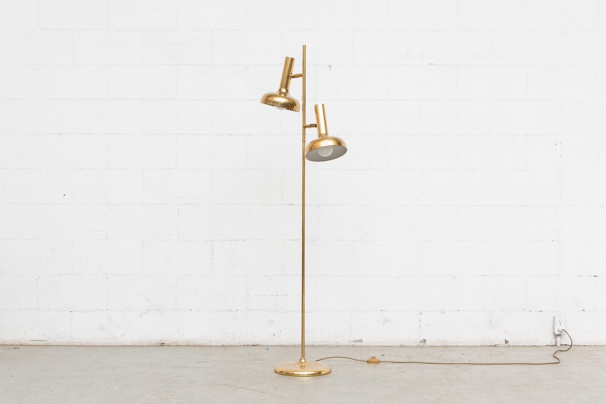 Very elegant double headed brass standing floor lamp. Each spot is can be arranged in different directions. Floor lamp is in good original condition with nice patina.