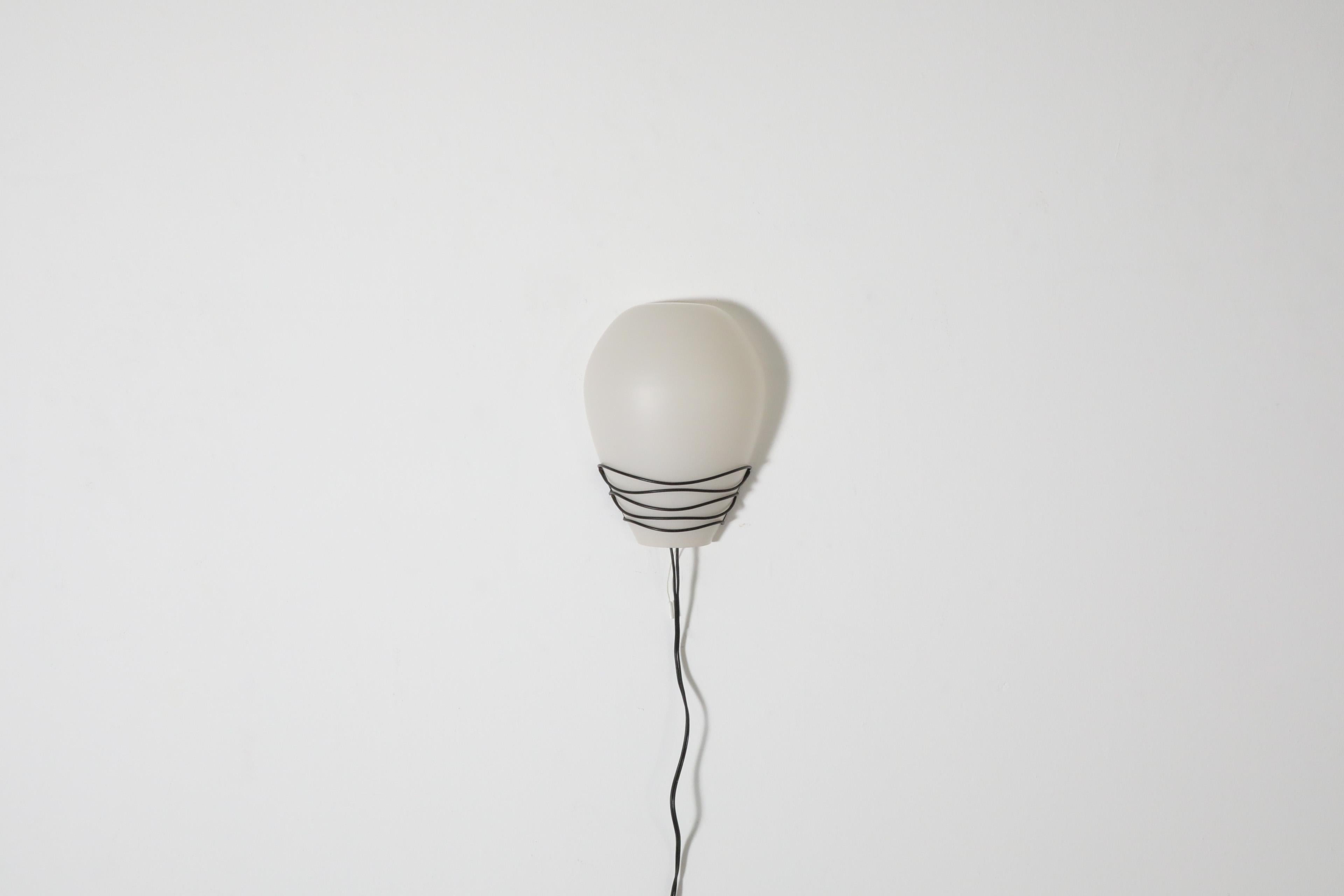 Mid-Century Philips 'NX20' wall sconce with decorative black wire frame and removable milk glass shade. A stylish pairing of glass and wire in original condition with visible wear consistent with its age and use.