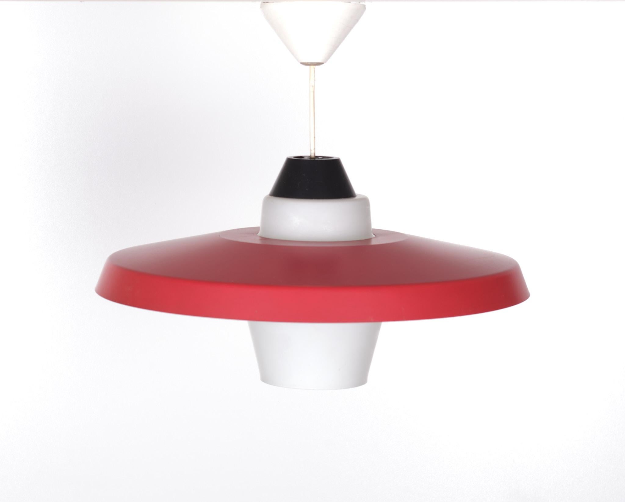 Lampada da soffitto molto bella, con anello in metallo rosso e paralume in vetro opalino.
Tipico design olandese. Prodotto da Philips. Design di Louis Kalff 1960 
Una lampadina E27 grande.

 