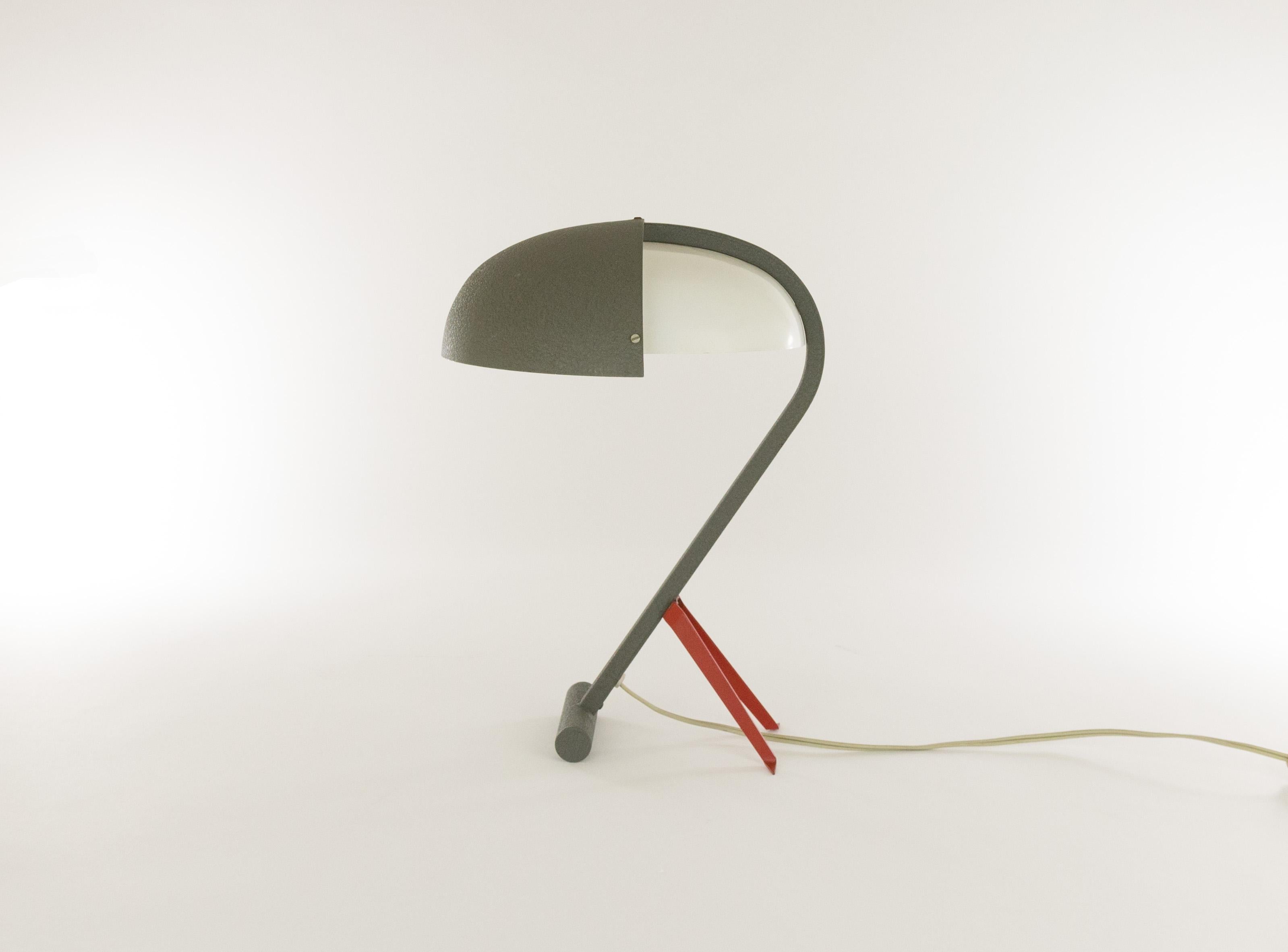 Rare lampe de table, modèle NX 110, conçue par Louis Christiaan Kalff pour Philips Eindhoven.

Il est doté d'un cadre en acier gris ; l'abat-jour est constitué du même matériau et de métal peint en blanc. Les petits pieds de soutien rouges donnent