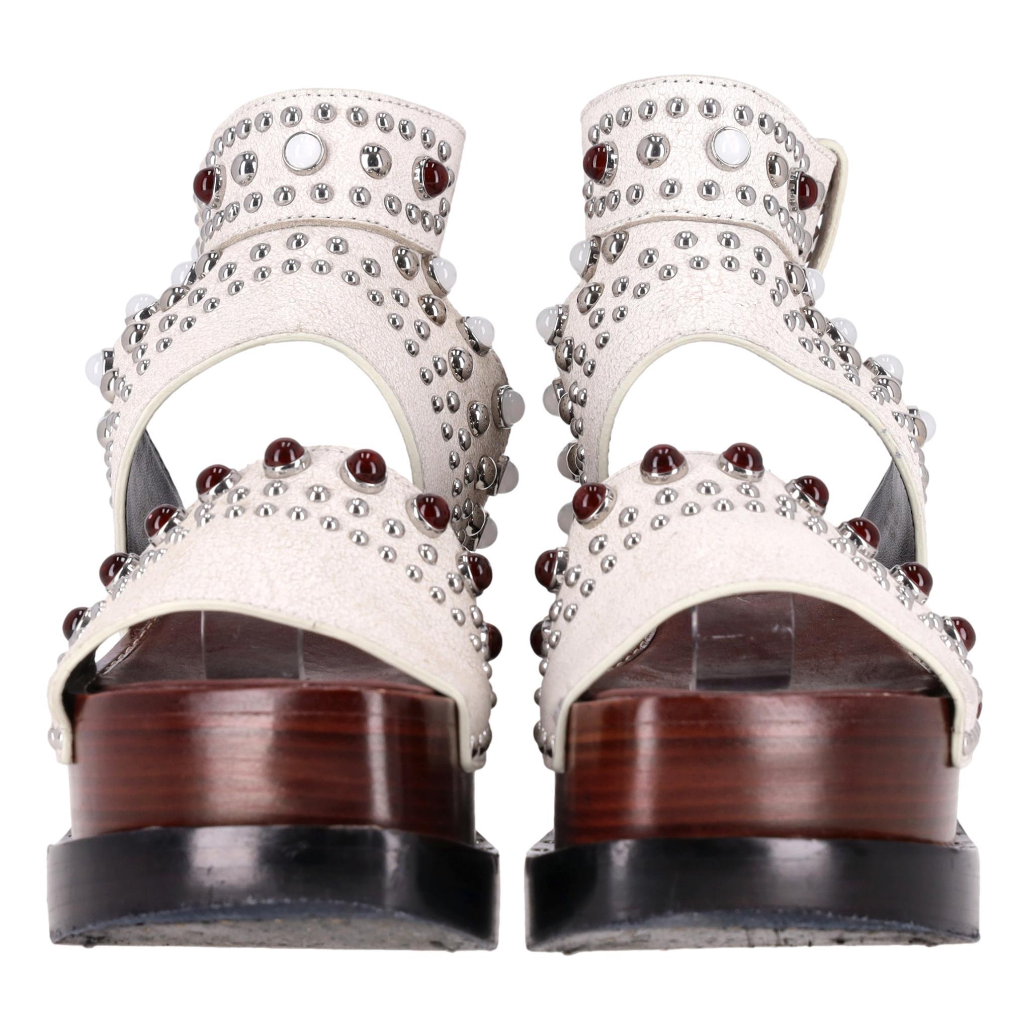 Sandales compensées Nashville cloutées en cuir Phillip Lim

Sandales en cuir blanc de style antique agrémentées de clous décoratifs en argent, bordeaux et blanc.

Ils sont dotés d'une plateforme en bois, d'un talon bloc et d'une fermeture à boucle à