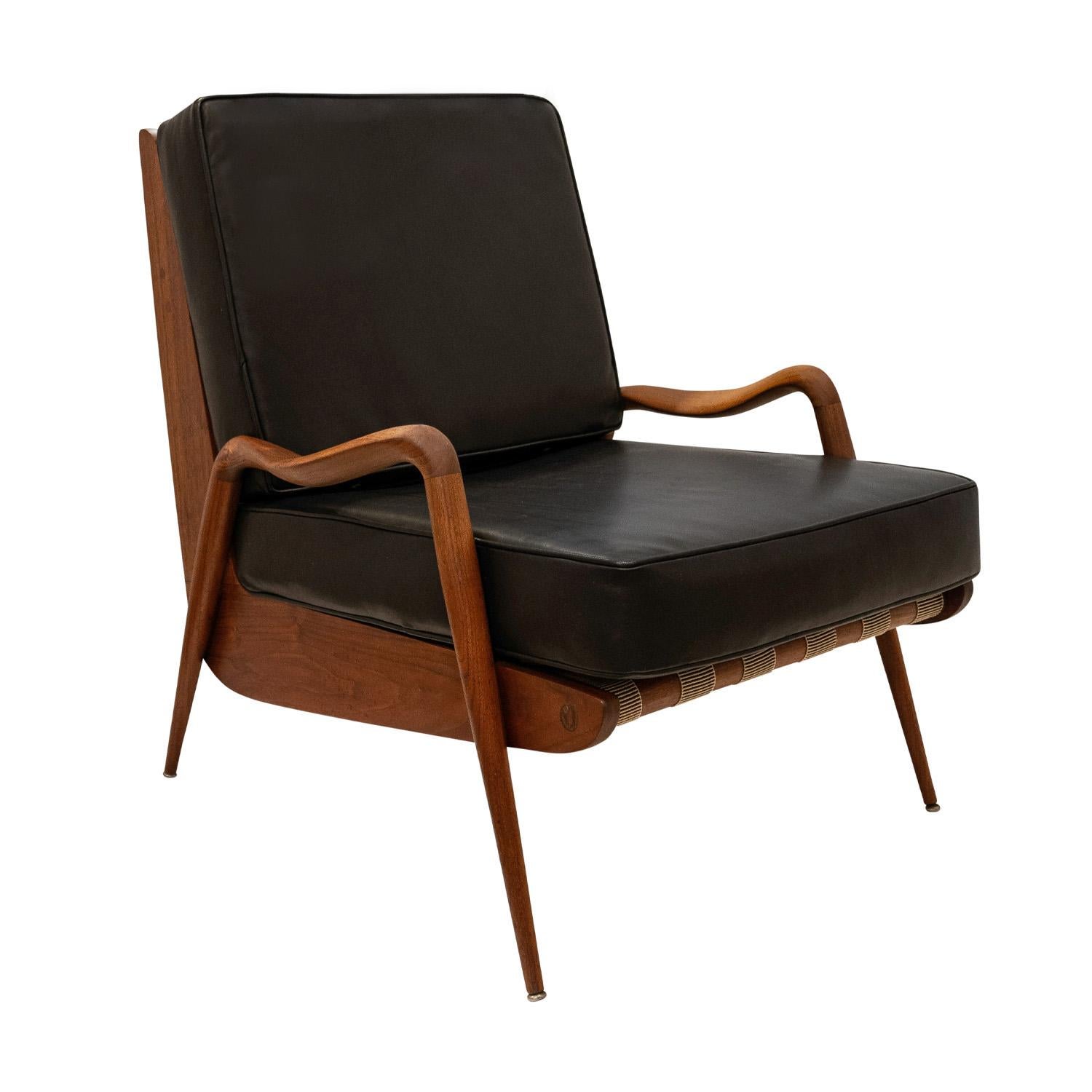 Rare high back lounge chair with frame in sculpted walnut with black leather seat and back cushions by Phillip Lloyd Powell, American early-1960’s.  The craftsmanship and attention to detail are superb.  Newly refinished and reupholstered in black