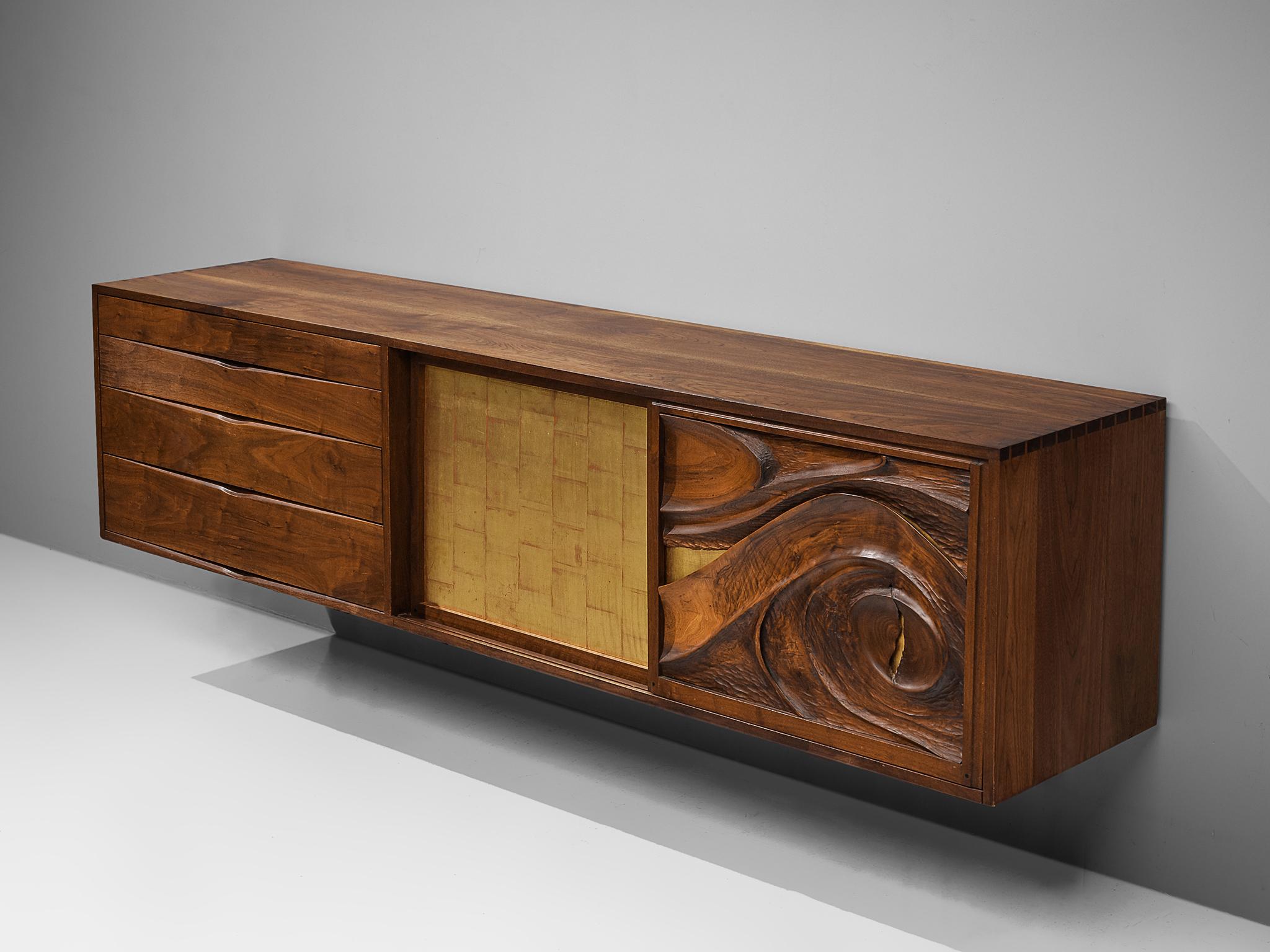 Phillip Lloyd Powell, wall-mounted cabinet, American walnut, gold leaf, United States, 1970s

This exquisite and elegant wall-mounted sideboard is designed by Phillip Lloyd Powell in the 1970s. The sideboard has three compartments, all with their