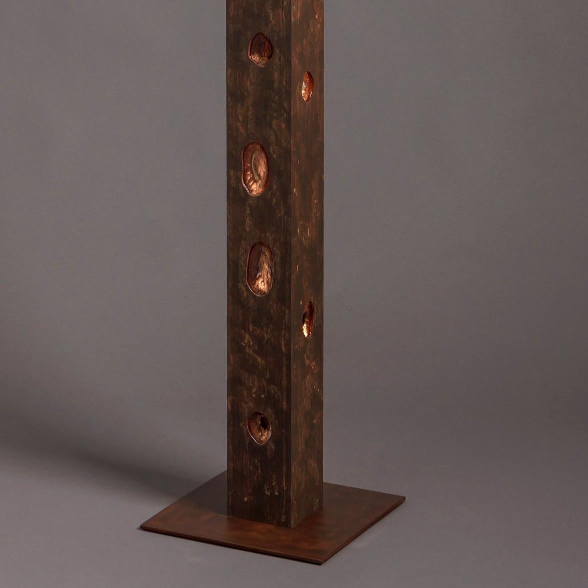 Philip Shore uses his art to illustrate man's relationship to the environment and how the connection between nature and culture is becoming more fractured. Ogham II was inspired by woodpeckers and is made of wood, natural objects, steel, metal leaf,