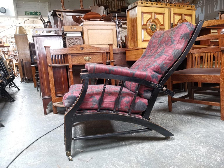 Phillip Webb for Morris and Co. Designed in C1866.
A rare Aesthetic Movement ebonized adjustable reclining armchair. The arched arms with padded armrests united to the sweeping arched legs by turned uprights, with adjustable reclining shaped back.