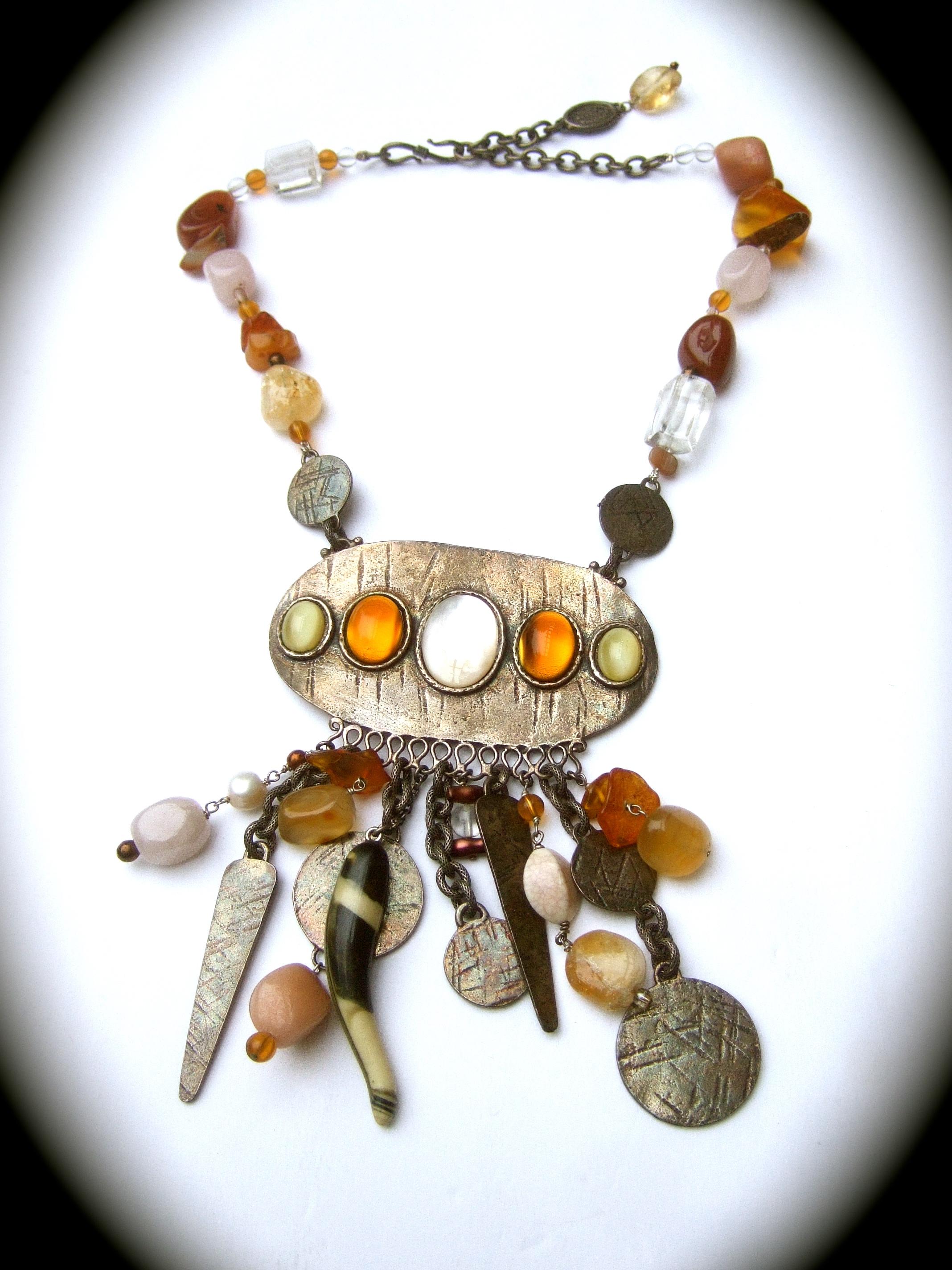 Phillipe Ferrandis Paris Artisan glass stone dangling charm necklace c 1980s

The exotic burnished silver-tone necklace is comprised of a collection of smooth glass stones, translucent crystals, 
resin cabochons with series of dangling burnished