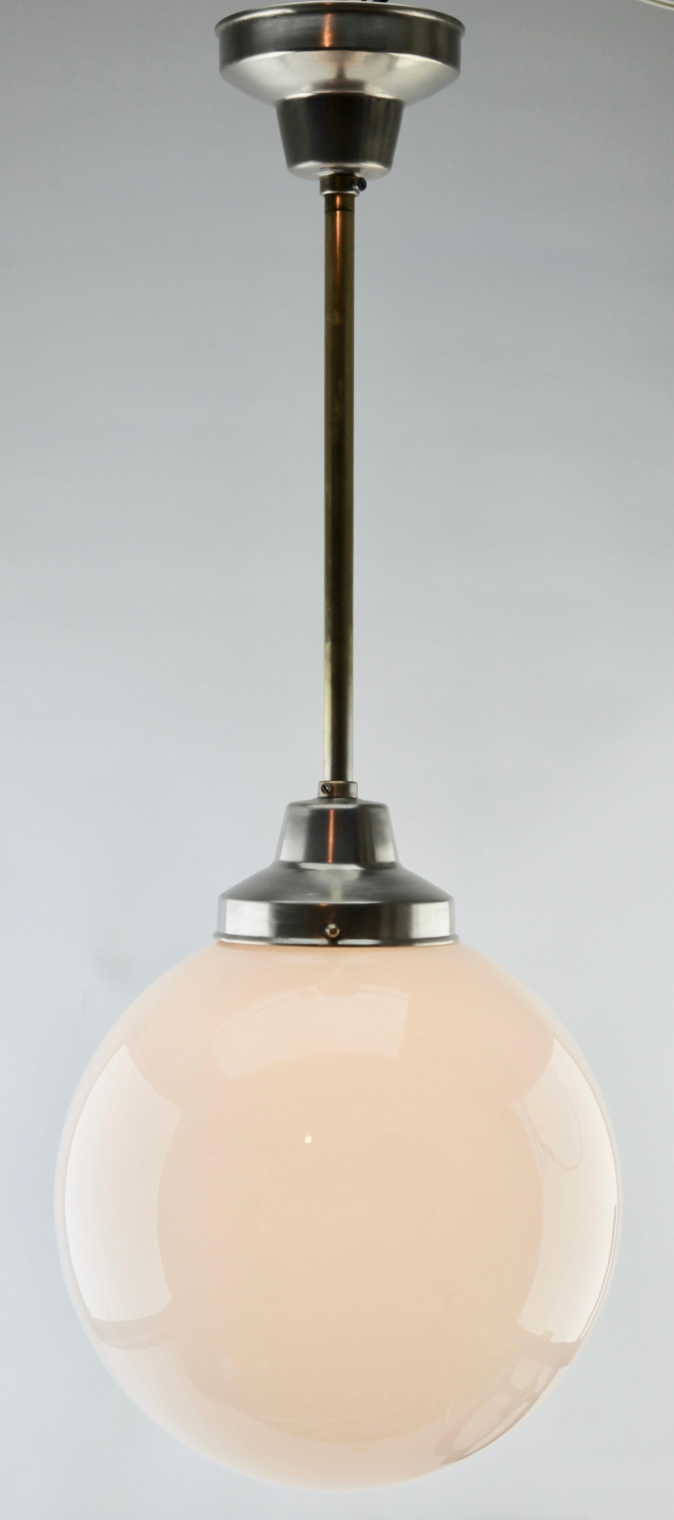 From the range by the Phillips Company, this center-light on a central chromed stem. the lamp has a fitting on a chromed plate and holds a round globular shade of opaline glass.

In good condition and in full working order with standard original