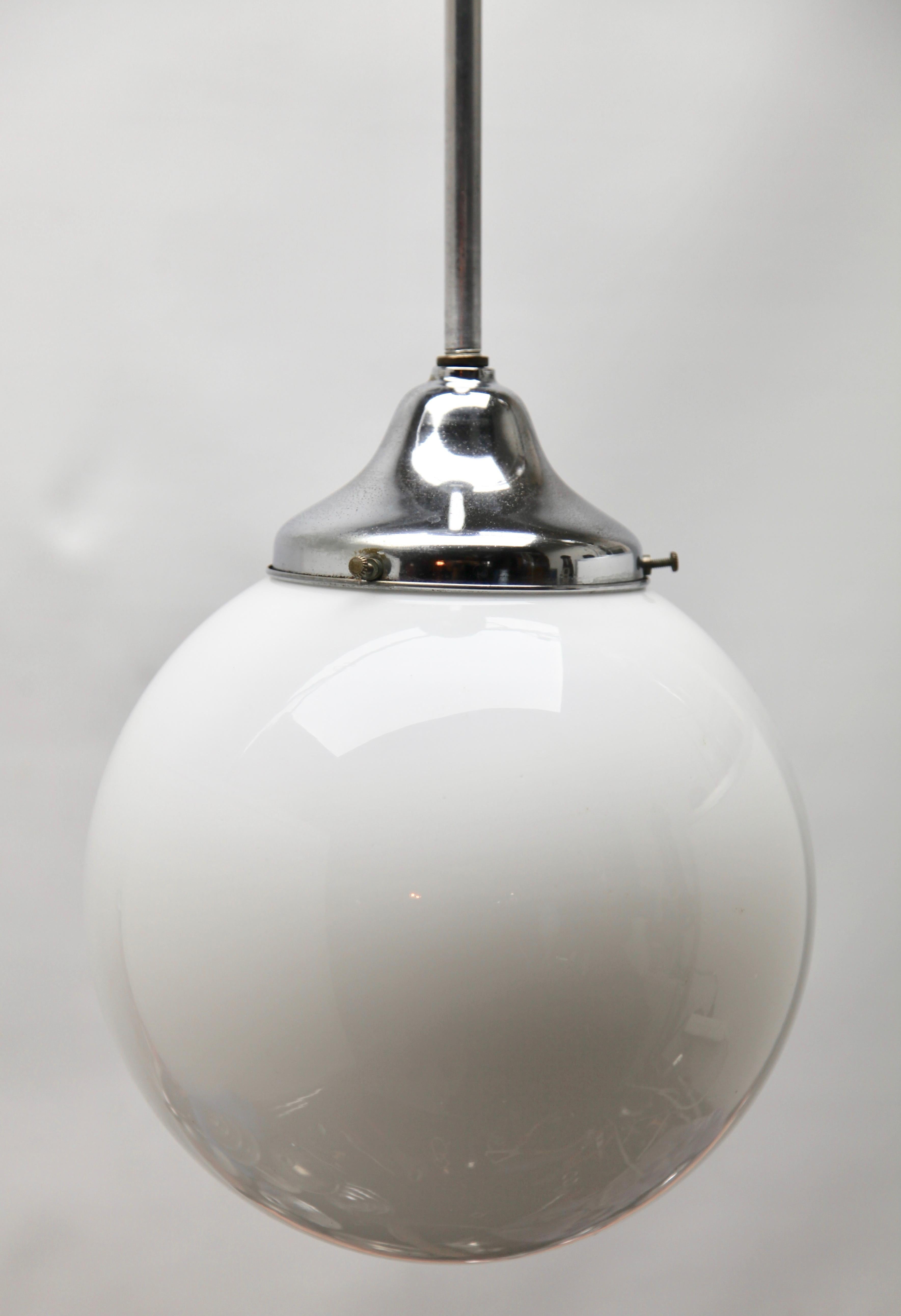 Issue de la gamme de la société Phillips, cette lampe de centre sur une tige centrale chromée. La lampe a une armature sur une plaque chromée et contient un abat-jour rond et globulaire en verre opalin.

En bon état et en parfait état de