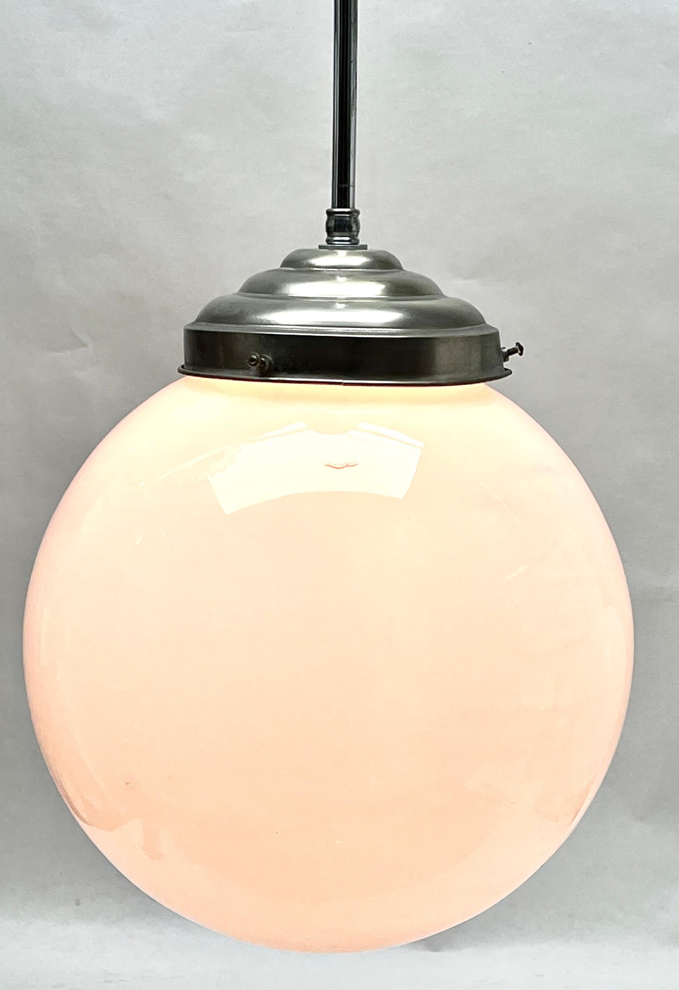 Aus der Reihe der Phillips Company stammt diese zentrale Leuchte auf einem verchromten Stiel. Die Lampe hat eine Halterung auf einer verchromten Platte und hält einen runden, kugelförmigen Schirm aus Opalglas.

In gutem Zustand und voll