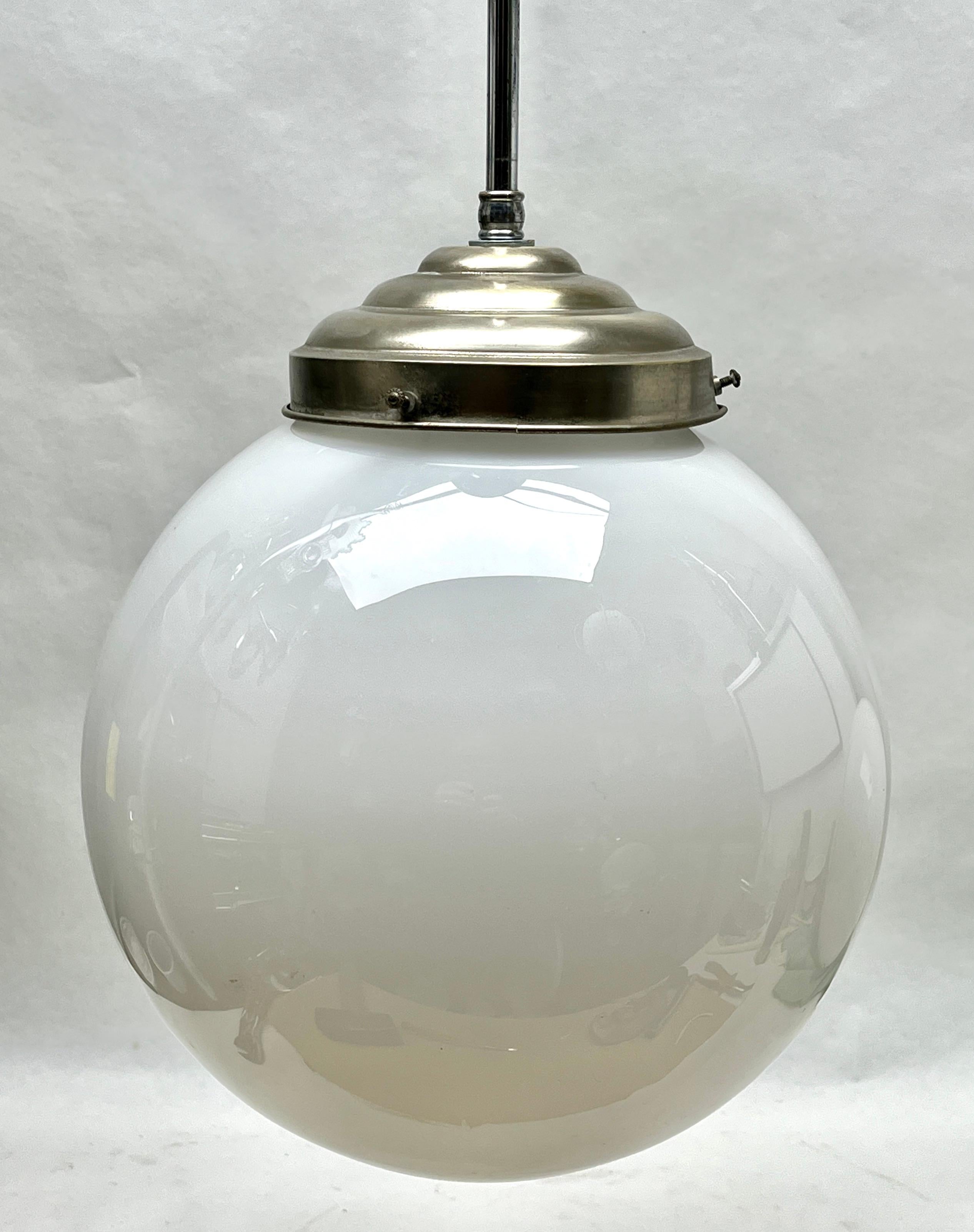 Aus der Reihe der Phillips Company stammt diese zentrale Leuchte auf einem verchromten Stiel. 
Die Lampe hat eine Halterung auf einer verchromten Platte und hält einen runden kugelförmigen Schirm aus Opalglas.

In gutem Zustand und voll