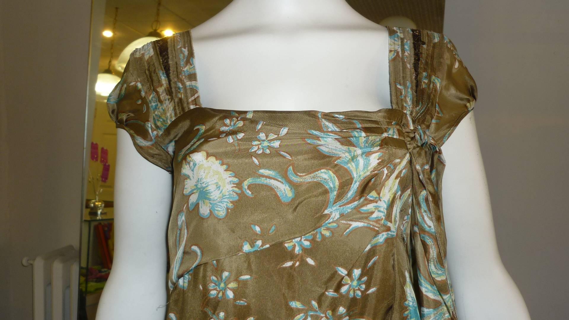 This silk floral pattern dress has never been worn and still has its tags. It looks like a very simple dress until you see details such as draped and pleated neckline with a side bow, and the pleat and sequin detail on the wide shoulder straps.
Can