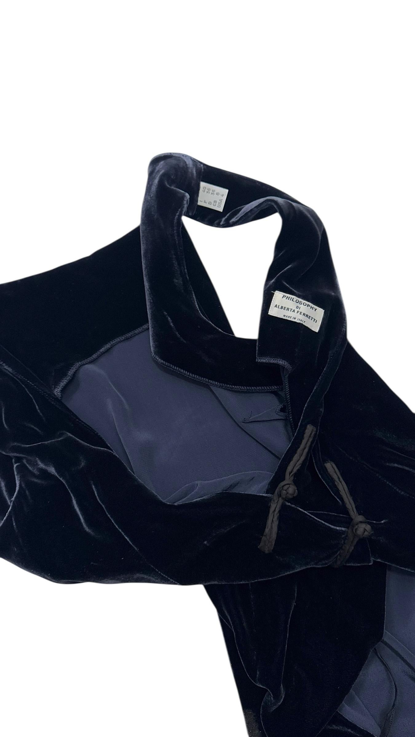 Ein seltenes und elegantes Vintage-Abendkleid von Philosophy di Alberta Ferretti, gefertigt aus einem prächtigen, tiefblauen Samt, der im Licht dezent schimmert. Dieses bodenlange Kleid hat einen tiefen V-Ausschnitt, der durch zwei orientalisch