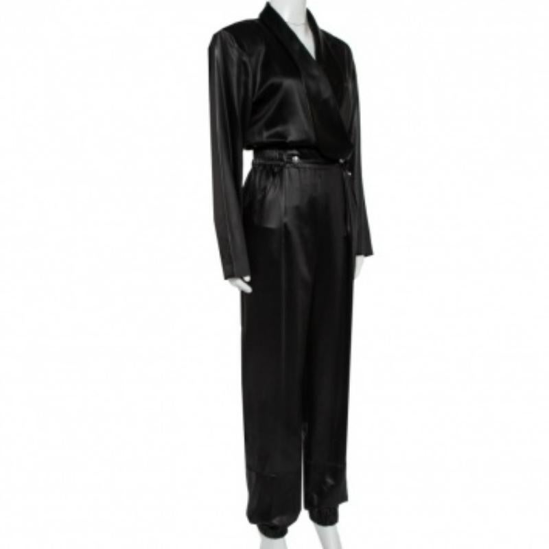 What's not to love about this jumpsuit from Philosophy Di Lorenzo! It comes well-tailored from sateen in a black hue. The jumpsuit features buttons on the front, two pockets, and long sleeves. A pair of high heels and gold accessories will